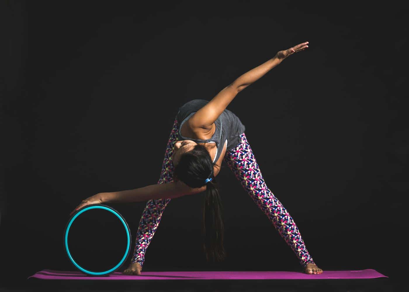 Gifts for yoga enthusiasts - woman working out with a yoga wheel