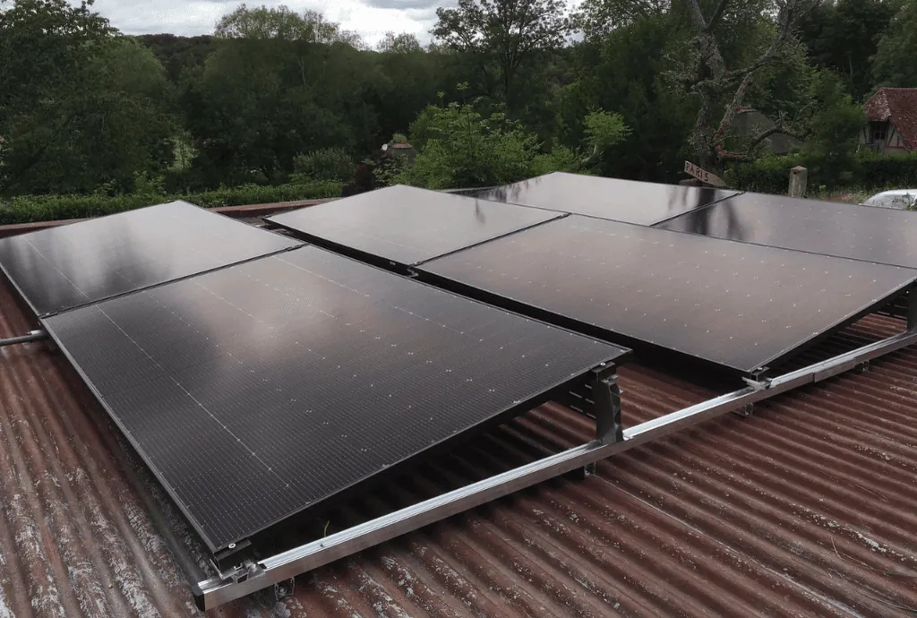 Photo de panneaux solaires de la marque DualSun qui ont été installés sur le toit d'une dépendence. On voit une maison en construction en arrière plan.