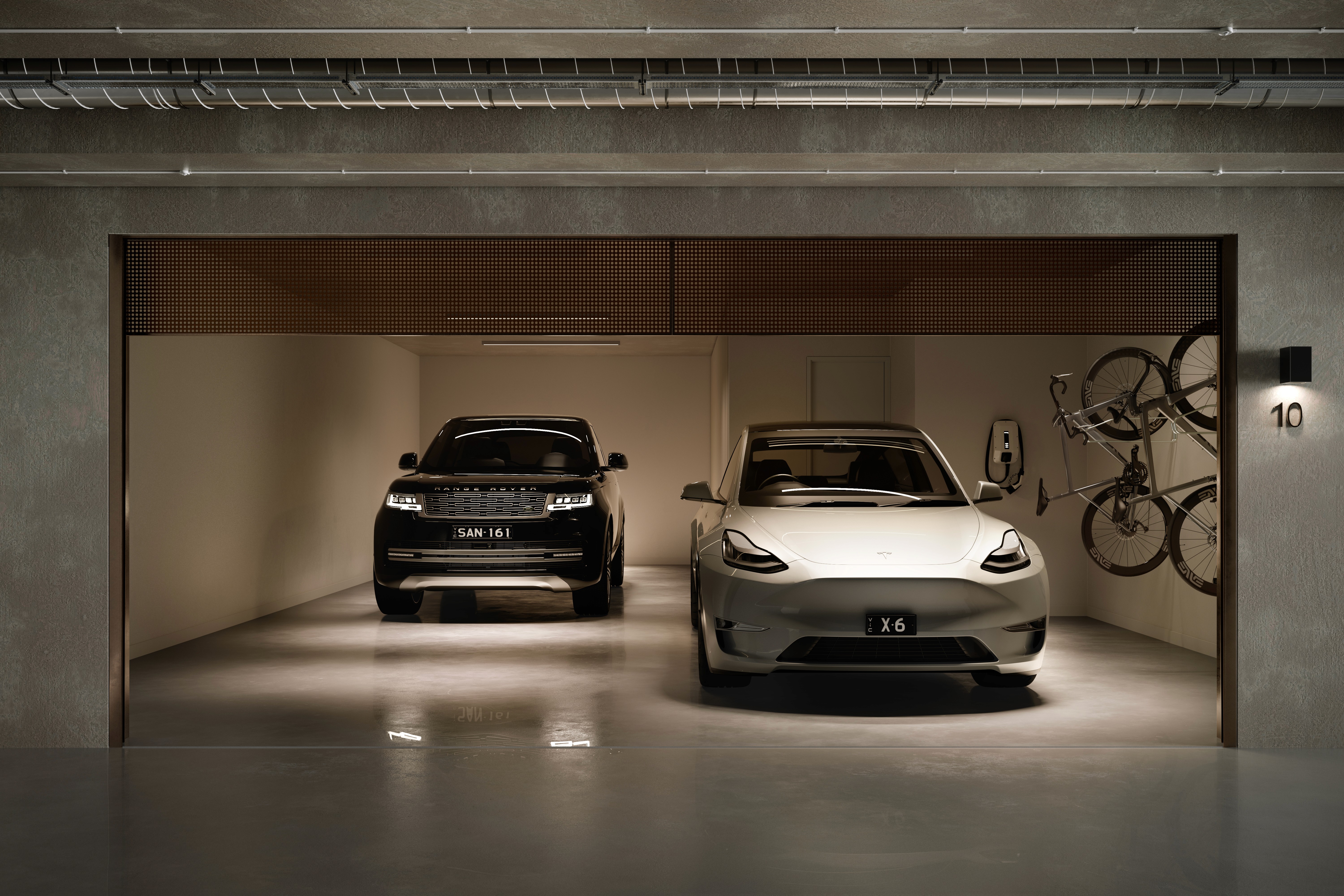 Luxury cars in modern garage with bikes and electric charger.