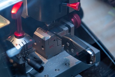 Laser key cutting machine precisely cutting a high-security car key blade.