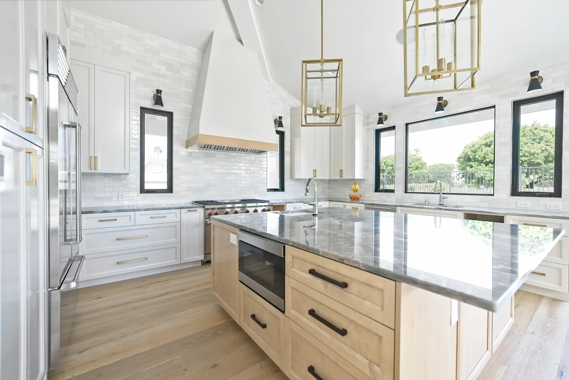 Wide shot at an angle of the kitchen showing the island and sophisticated subway tile backsplash, with a view towards the sink wall, highlighting the seamless blend of functionality and style in the Dana Point Full Remodel. Photo by Todd Huge.