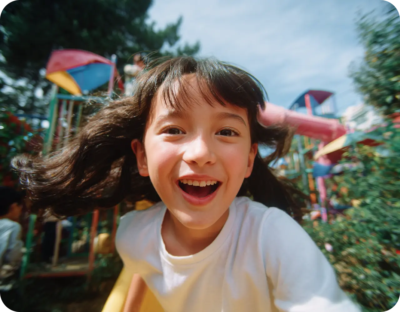 A joyful child smiles broadly, surrounded by iridescent bubbles in a sunlit garden, conveying a sense of happiness and playfulness.