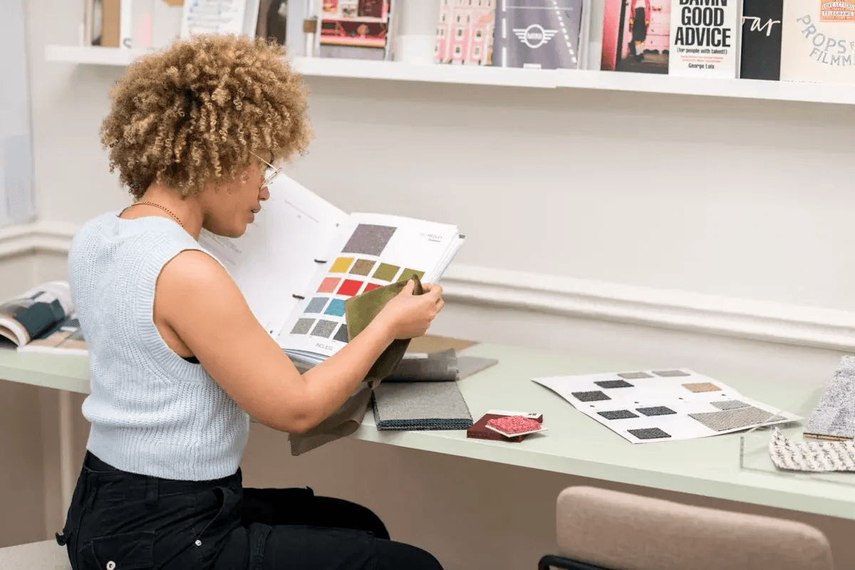 Person looking at a magazine on an art gallery shelf.
