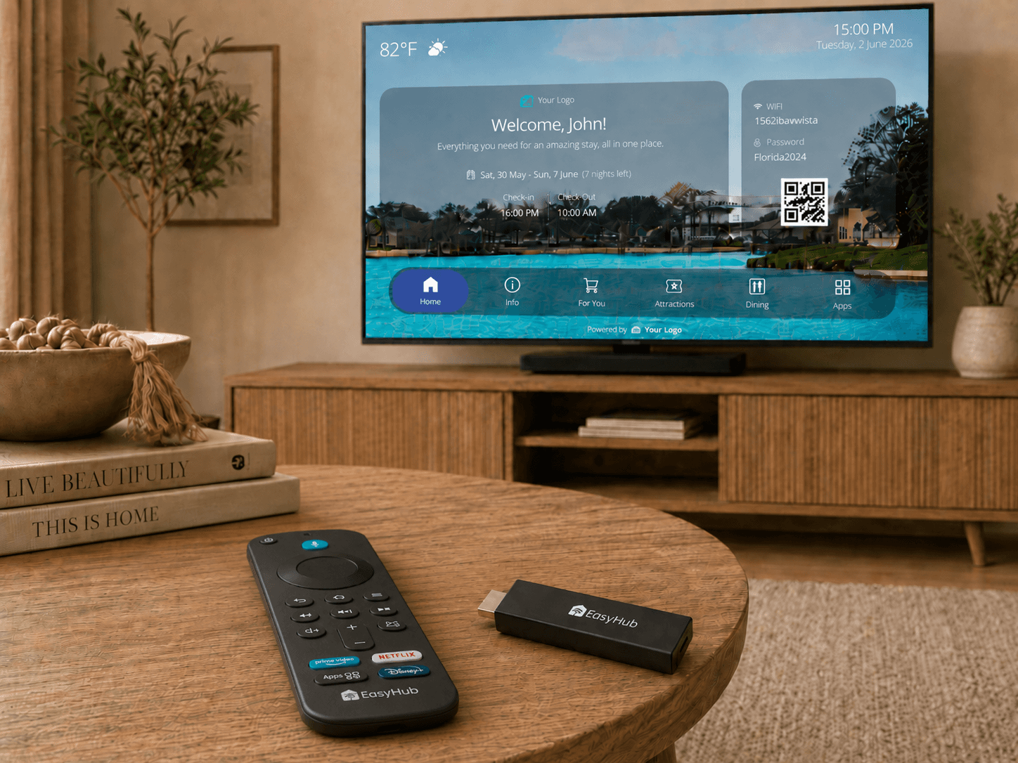 EasyHub device and remote control on a table, with a smart TV displaying a branded guest welcome screen in the background.