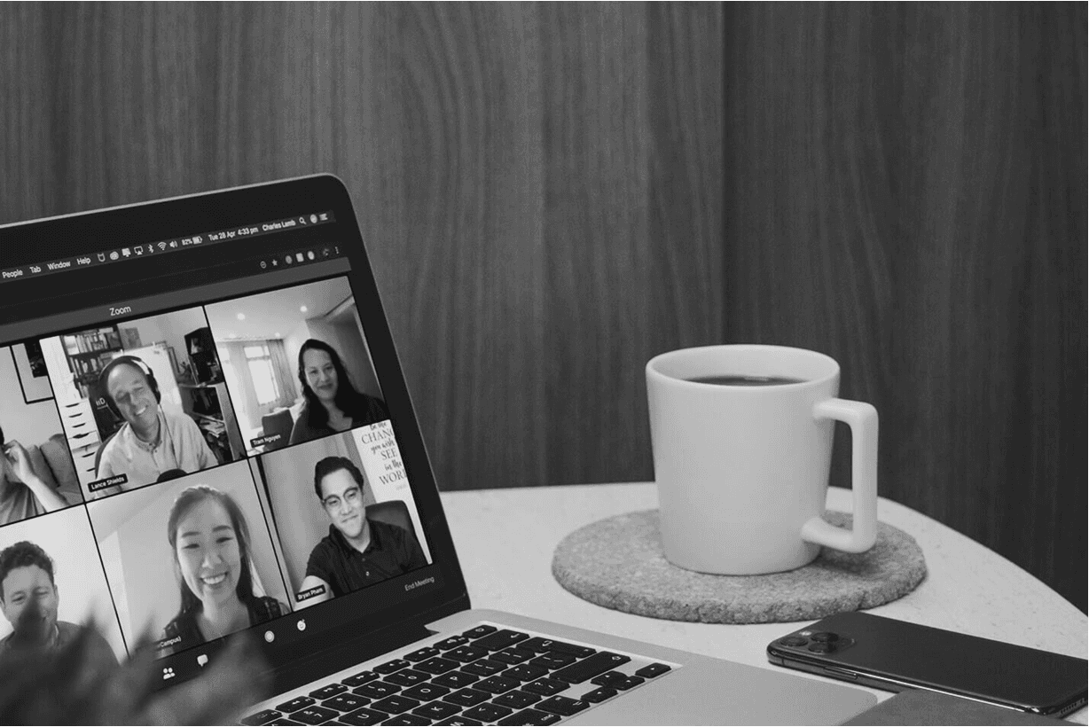 A woman with red hair and a black sleeveless top smiling confidently in a bright, modern indoor setting.