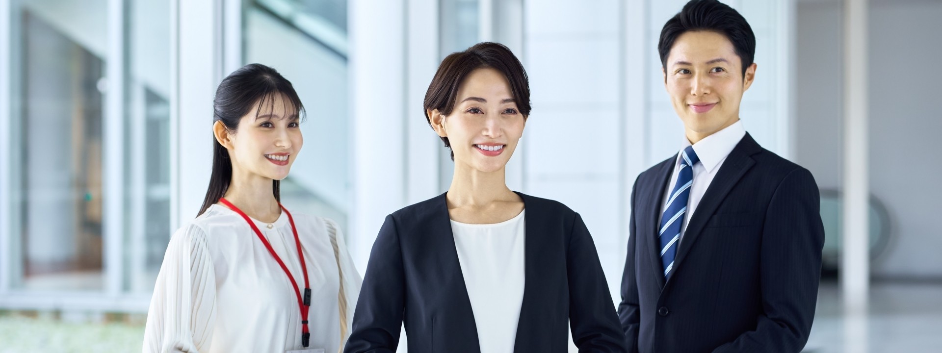 ビジネスマン、OLが3名笑顔で立っている