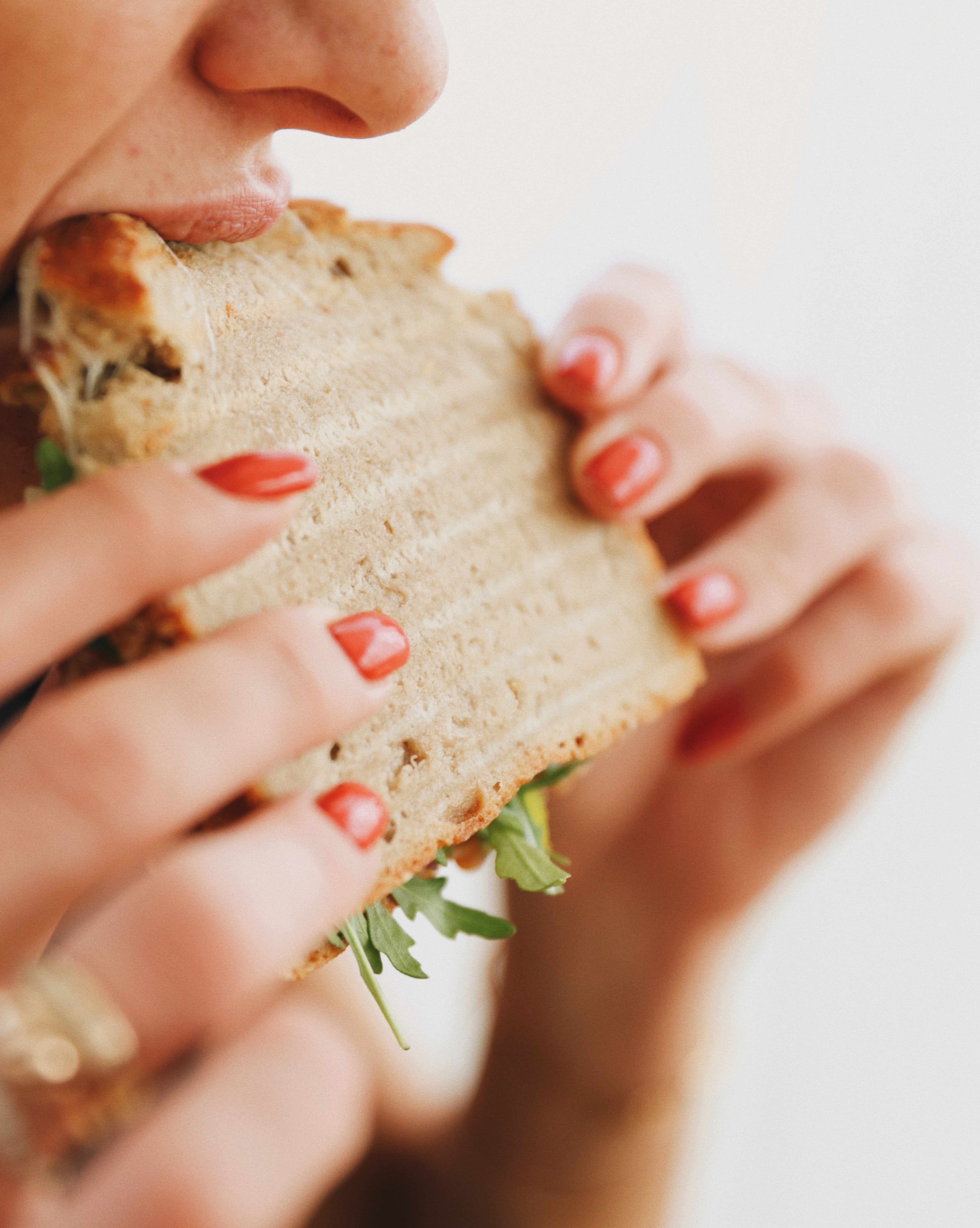 person holding clear drinking glass with brown liquid