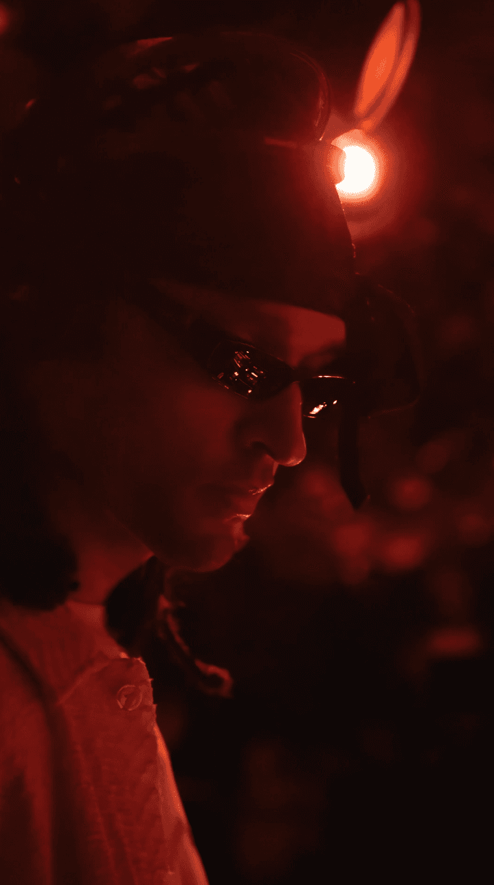 Woman in black outfit posing with arms raised