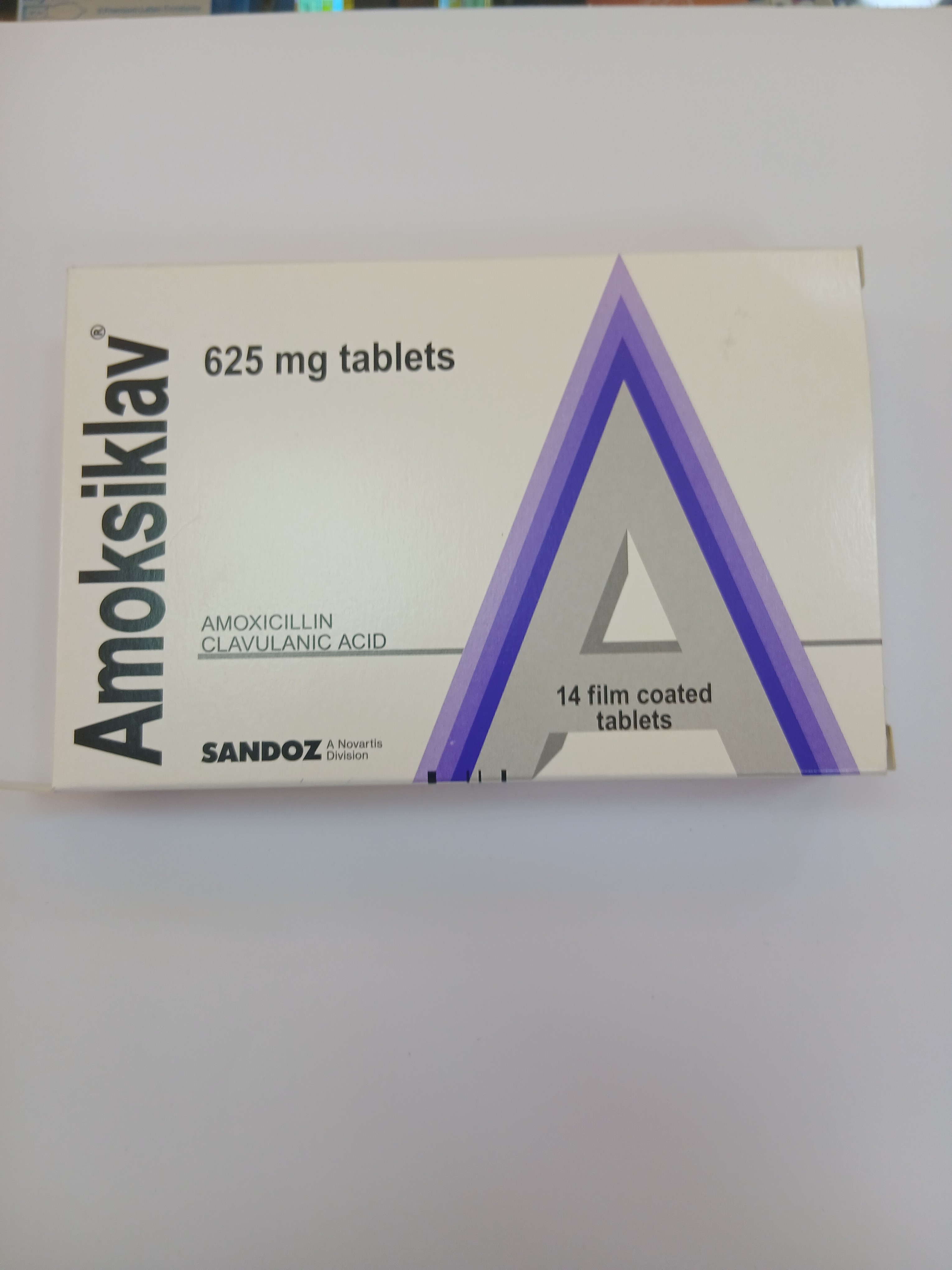 White and purple cardboard packaging displays a triangular arrangement of a blister pack containing 14 light purple film-coated tablets.