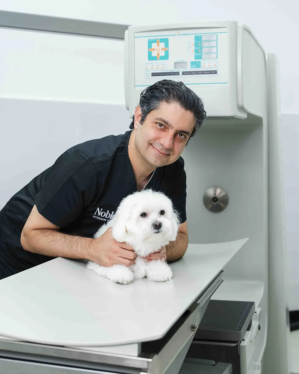 Dr. Day with a white dog in the cardiology lab.