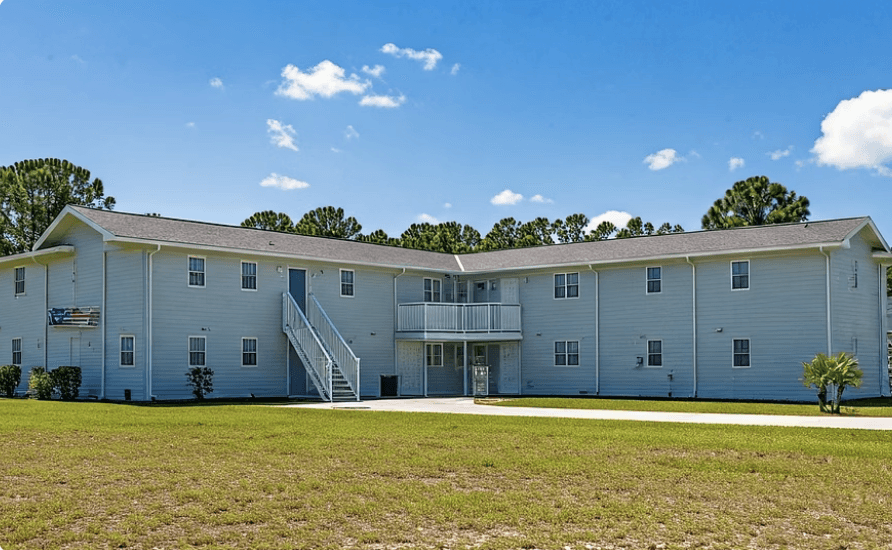 Aerial view of a hydroelectric dam spanning a turquoise river surrounded by dense forest and winding roads