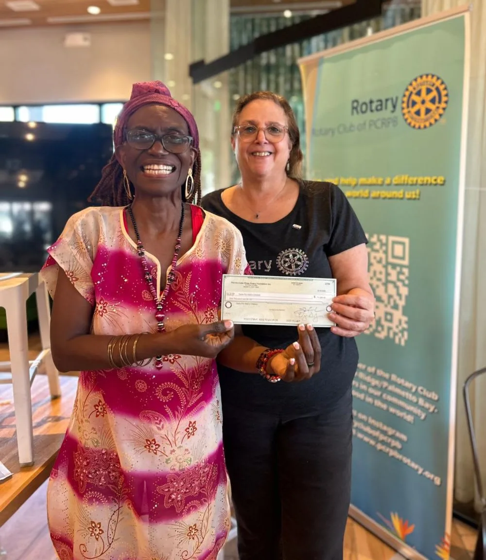 Yanick "Nicky" Lindquist receives a $1,000 contribution from the Perrine-Cutler Ridge/Palmetto Bay Rotary Club.