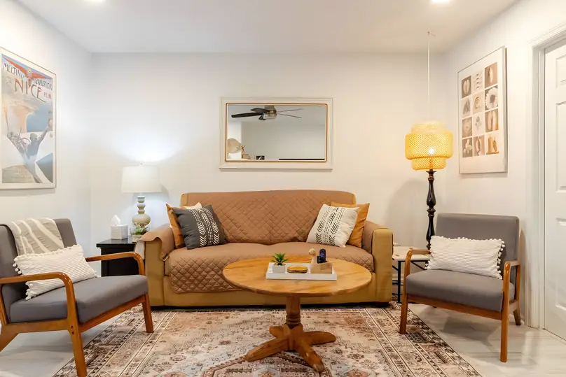Living room with a camel sofa, round coffee table and two armchairs