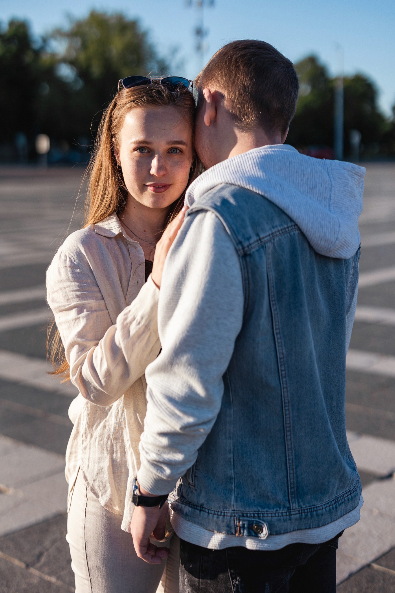 Egy pár ölelkezik Hősök terén napsütéstben.