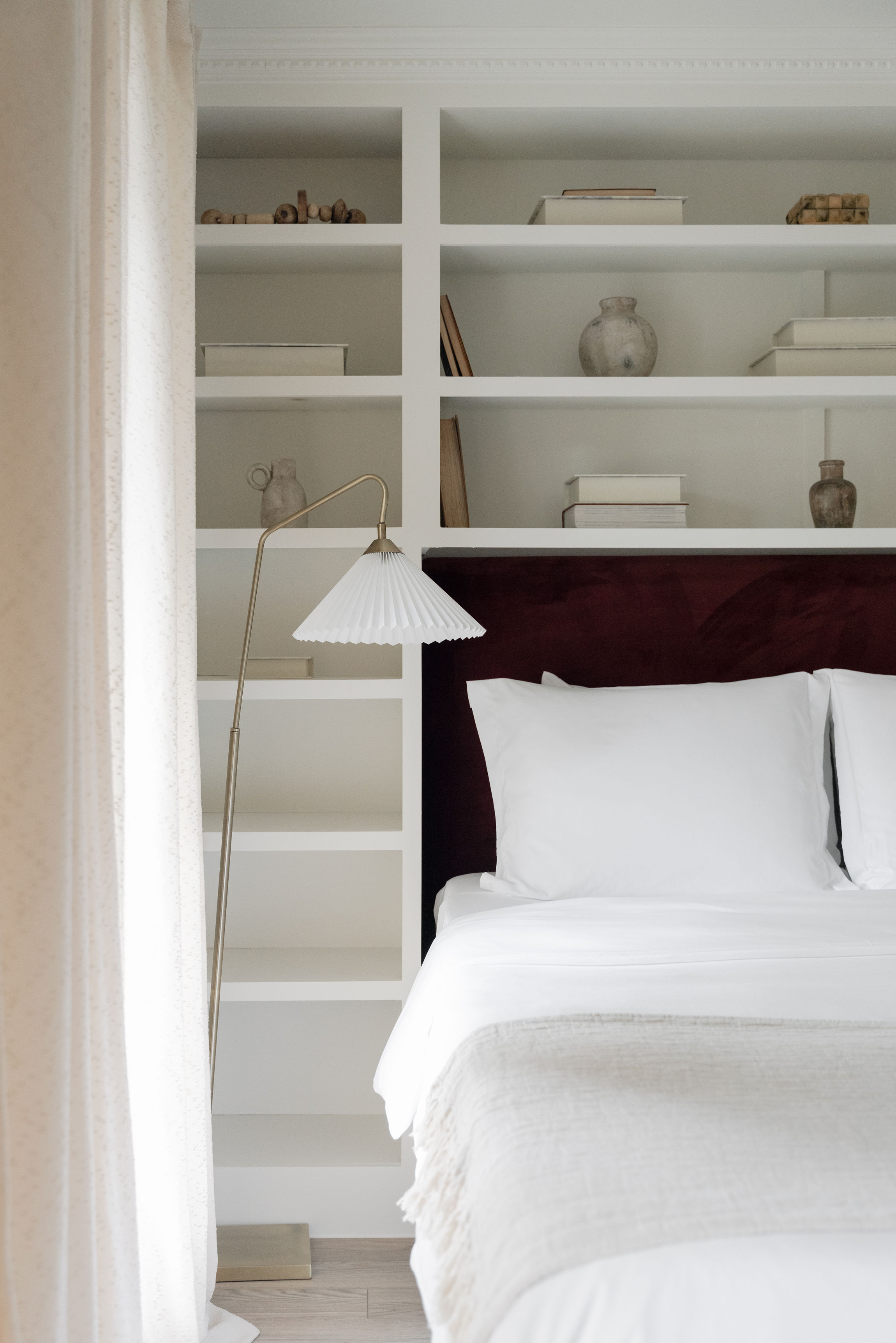 White bedding and shelves with decor on side