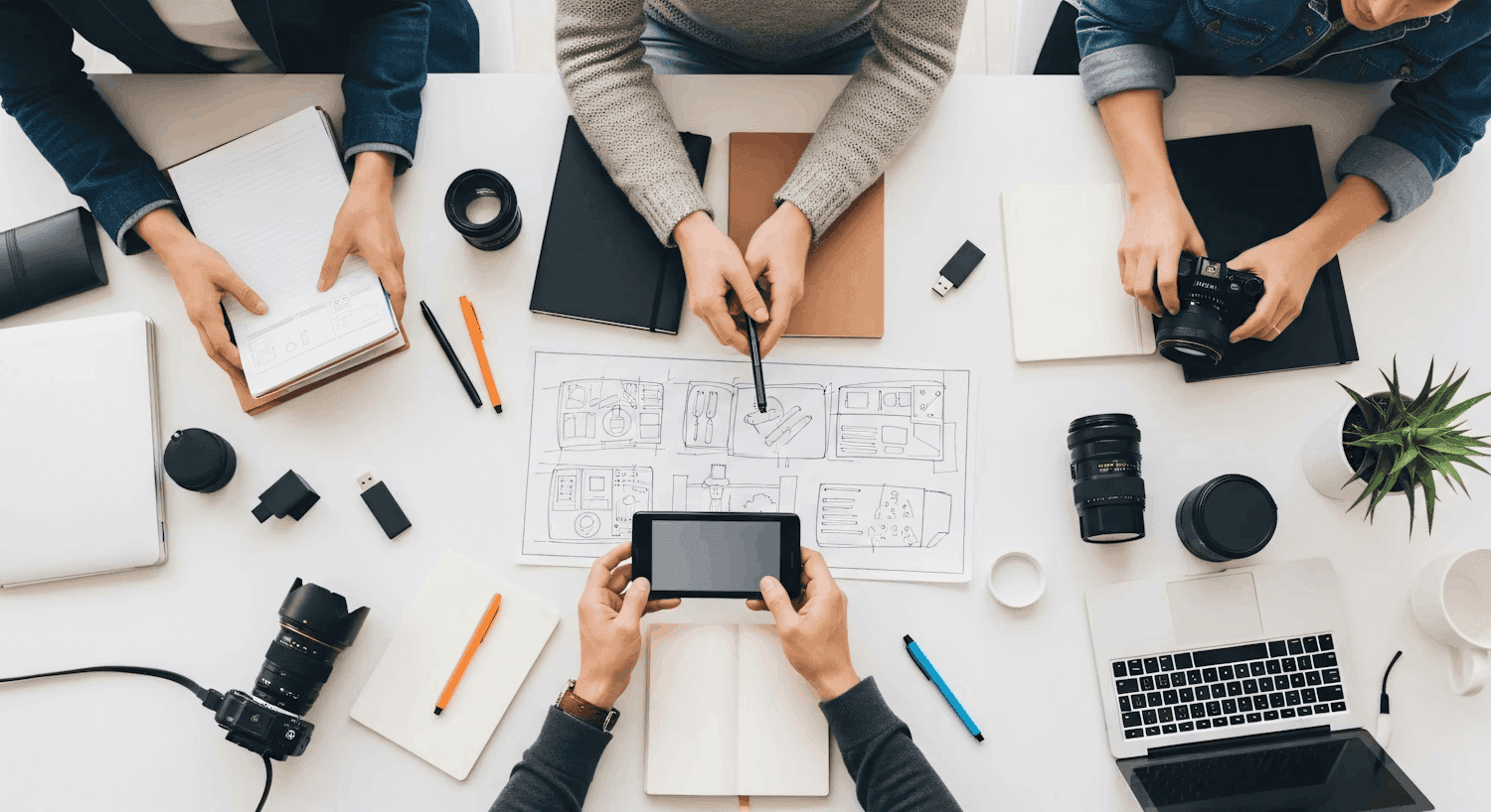 Team collaborating around desk with devices representing UI UX strategy
