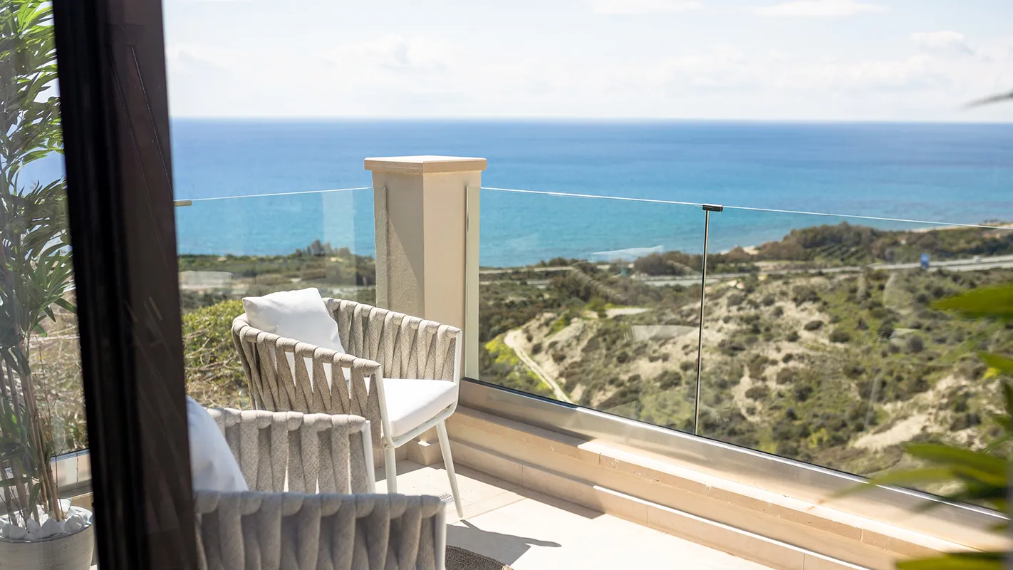 White Cedar House Mediterranean balcony seating with glass railing and sweeping coastline and sea views