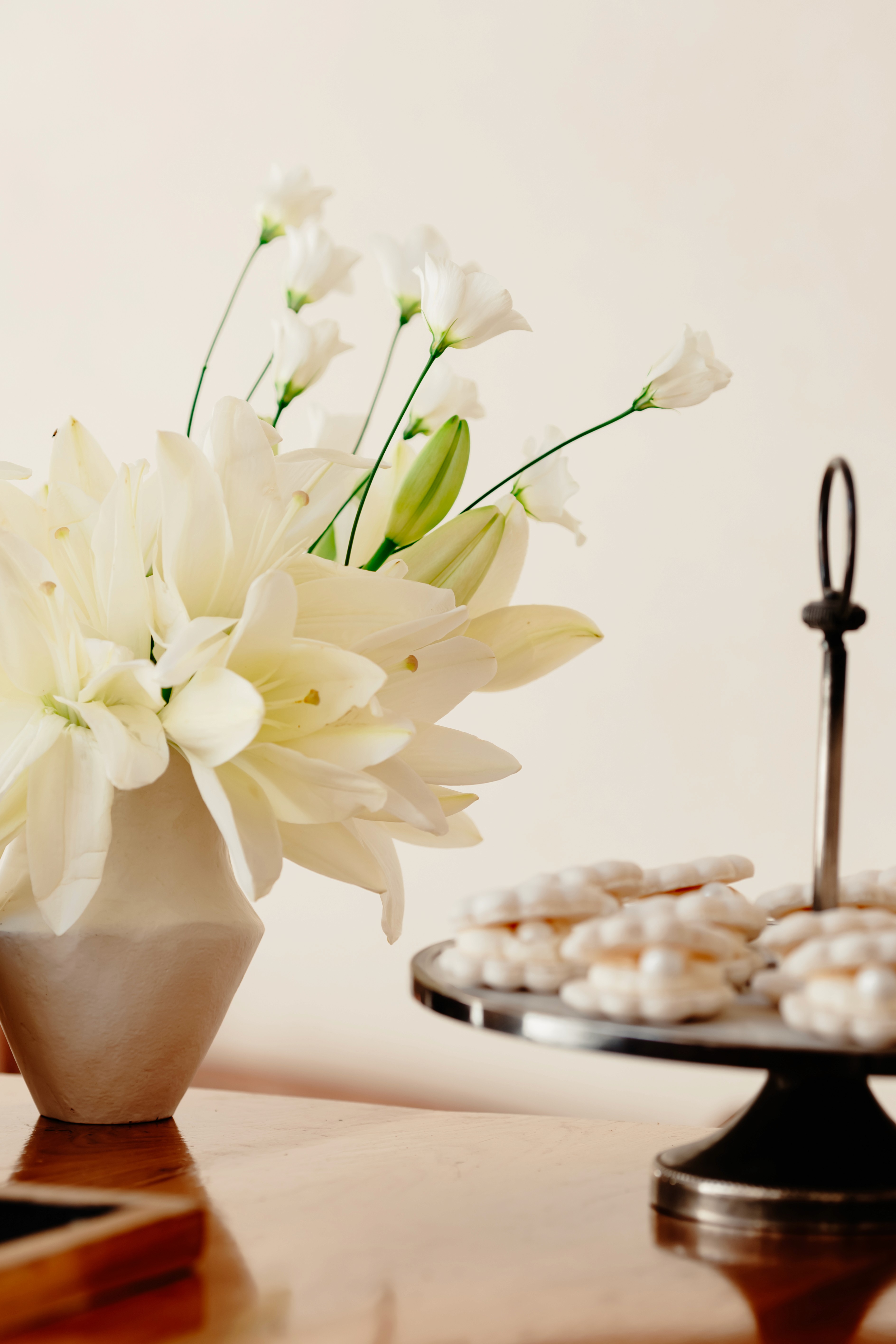 A couple in wedding attire walks hand in hand across a sunlit field.