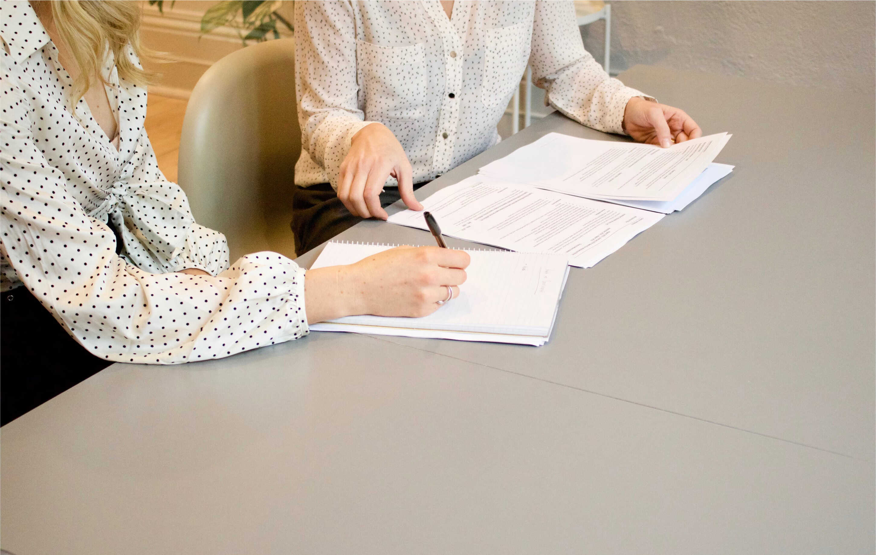 Women dressed professionally writing on papers