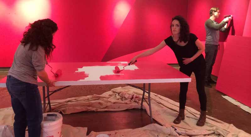 students painting the desk in red