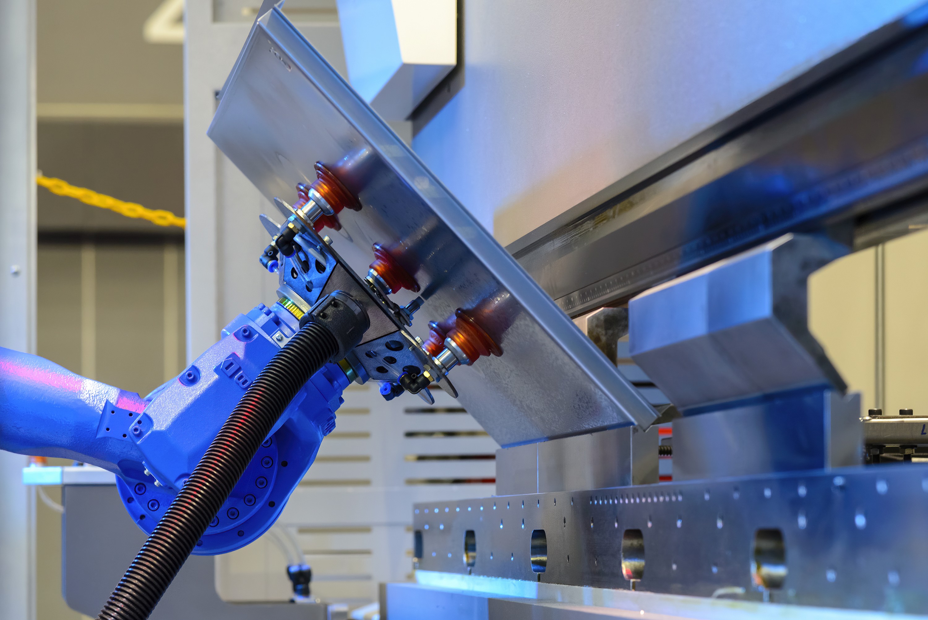 A close-up of a hand using a tool on metal equipment with bright blue lighting in the background.