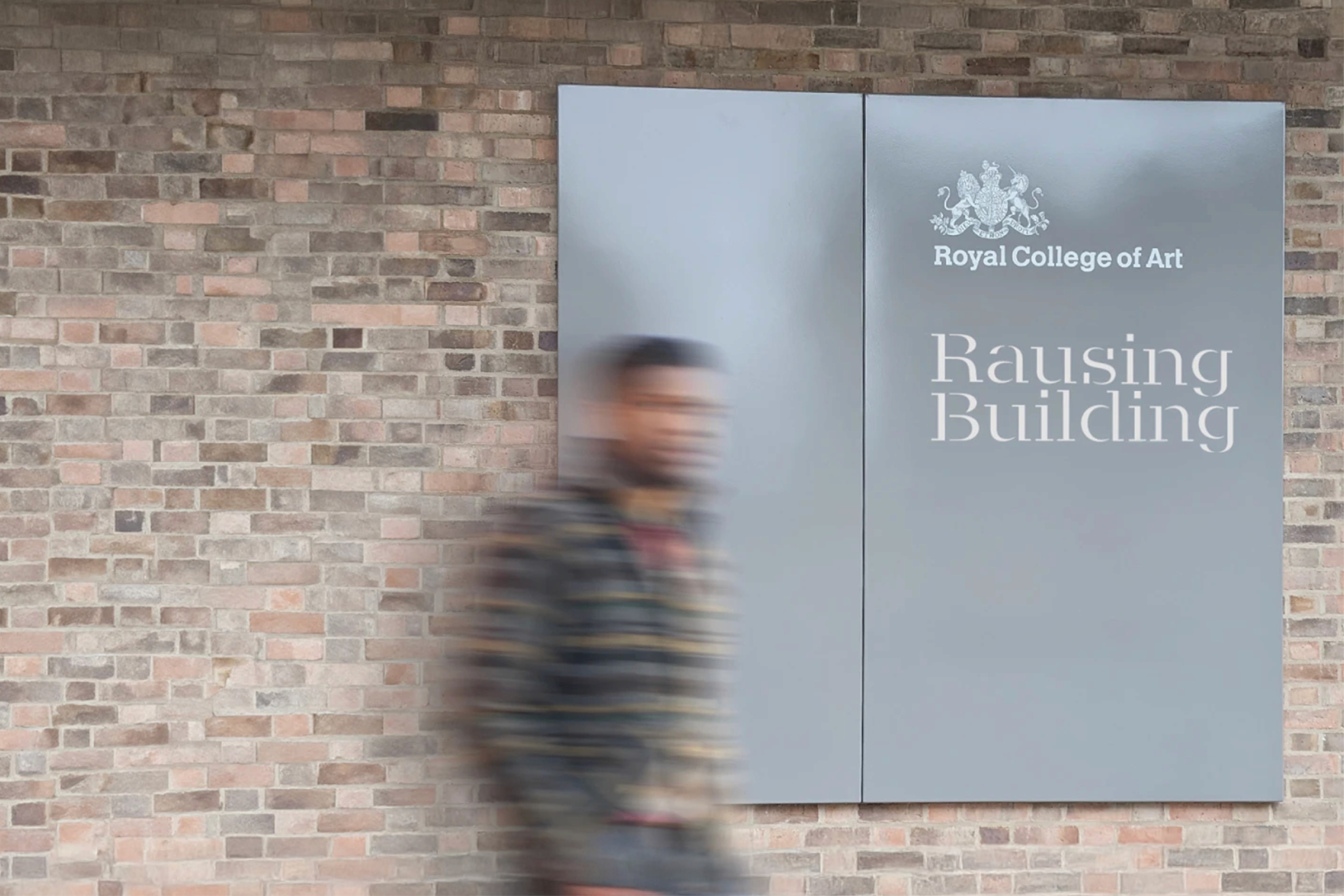 A person stands beside a large book titled "Demystifying Leadership" against a stone wall.