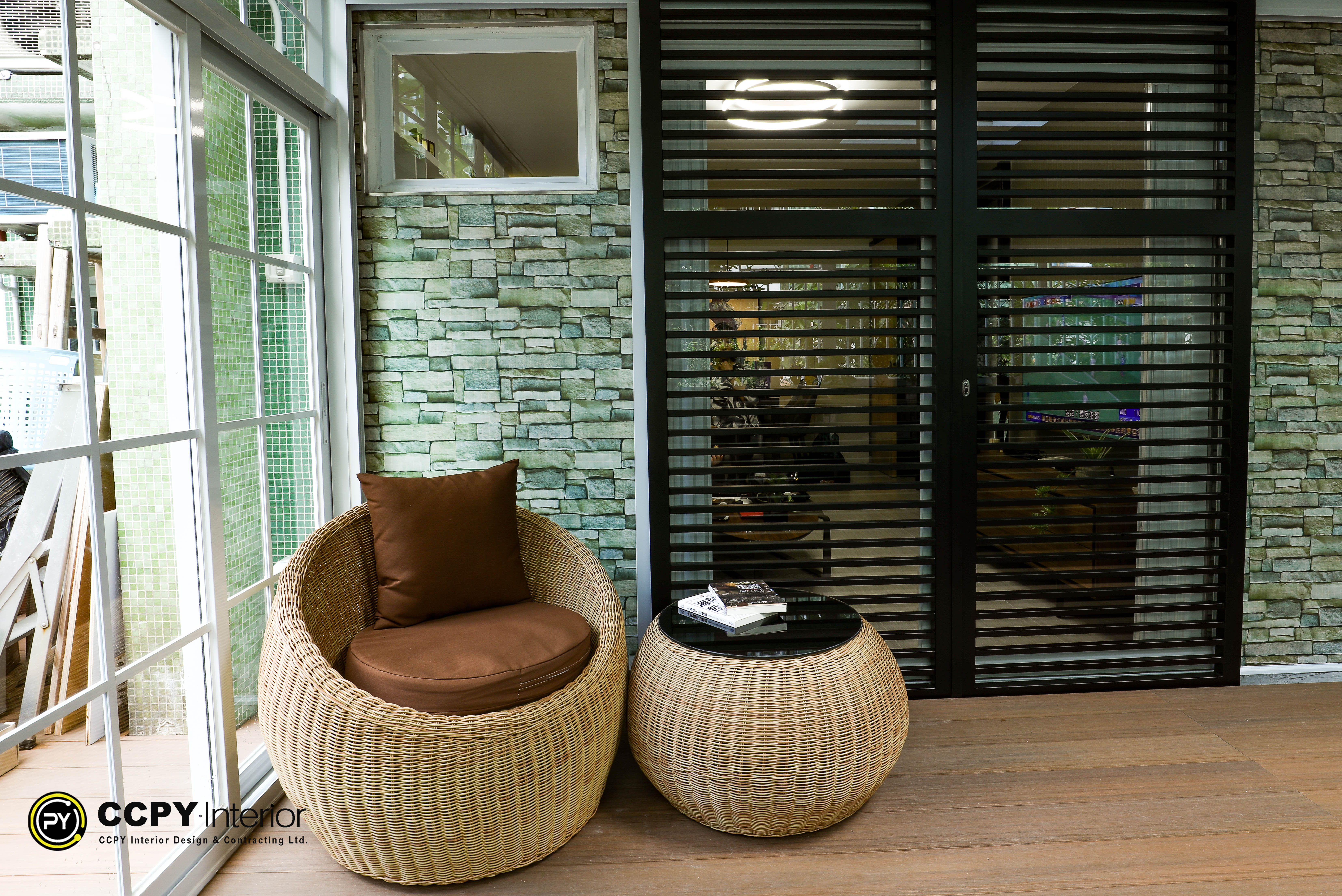 Sunroom with wooden shelving holding books and potted plants, visible outdoor greenery, and light wood decking at Kwan Lok Sun Chuen.