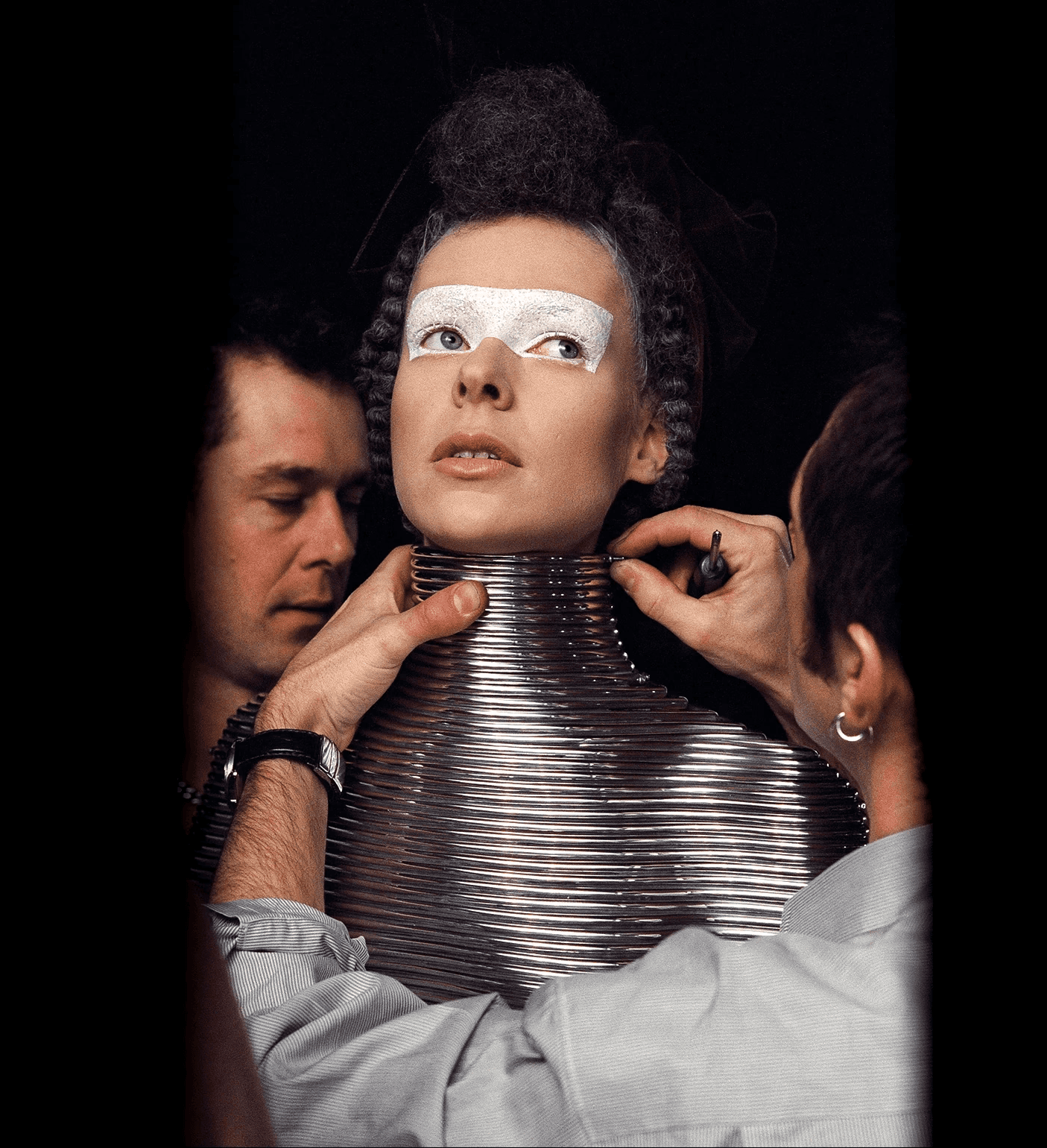 Backstage view of a model being fitted into the iconic silver metal Coiled Corset, a couture body armour collaboration between jeweller Shaun Leane and designer Alexander McQueen.