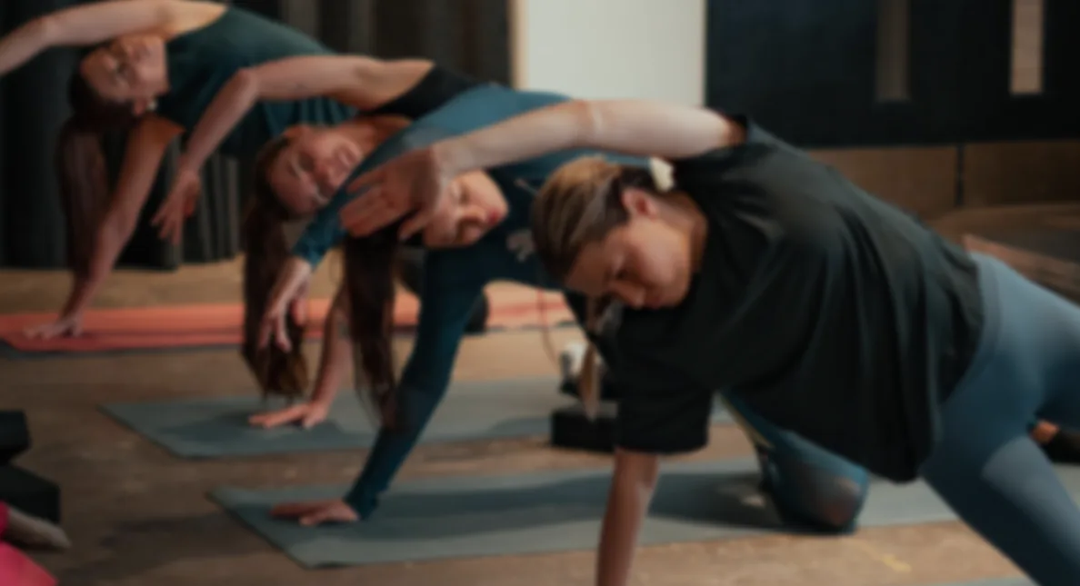 People stretching on mats during a group mobility class