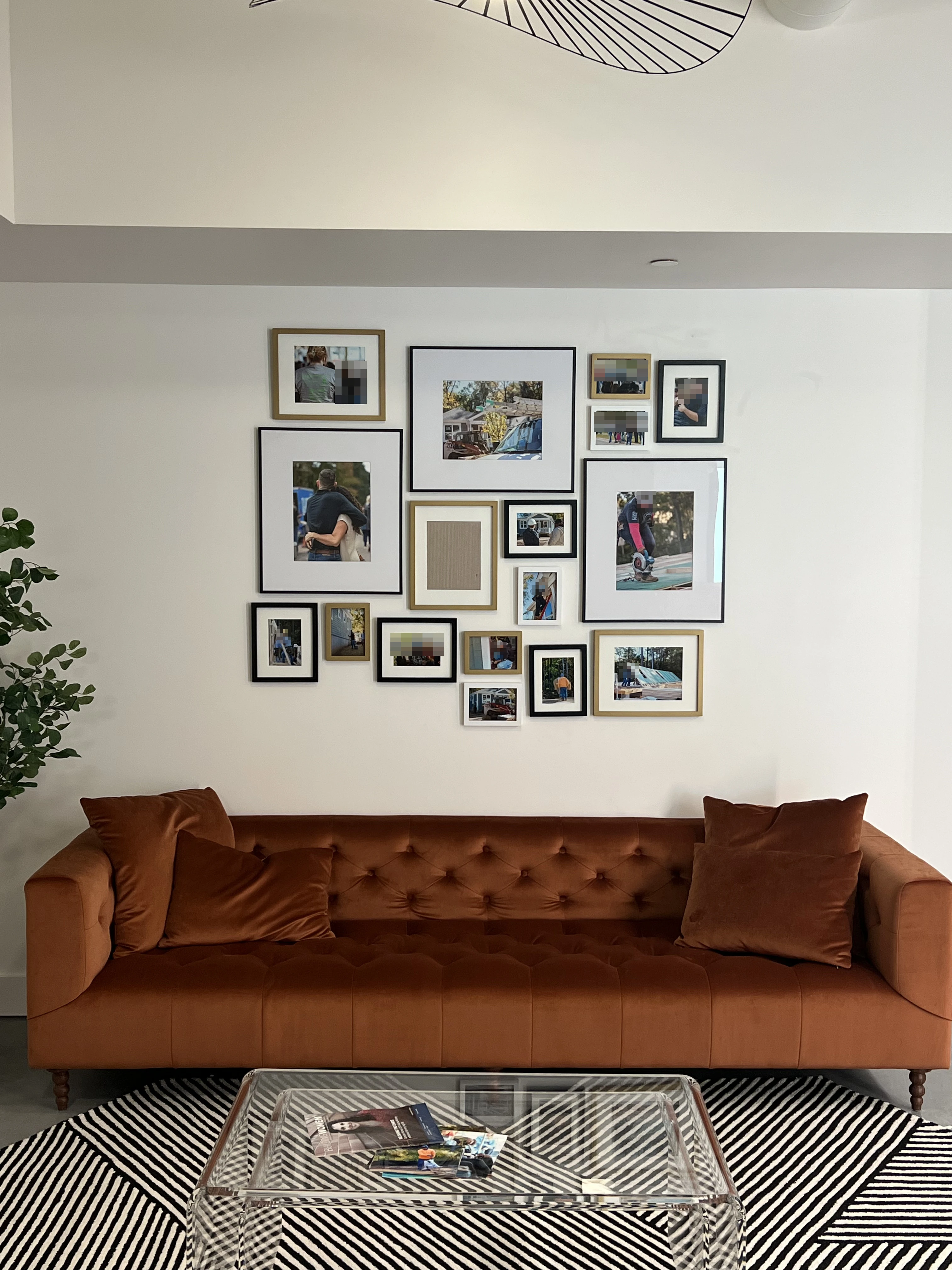 Mixed-size framed gallery wall above a rust-colored sofa.
