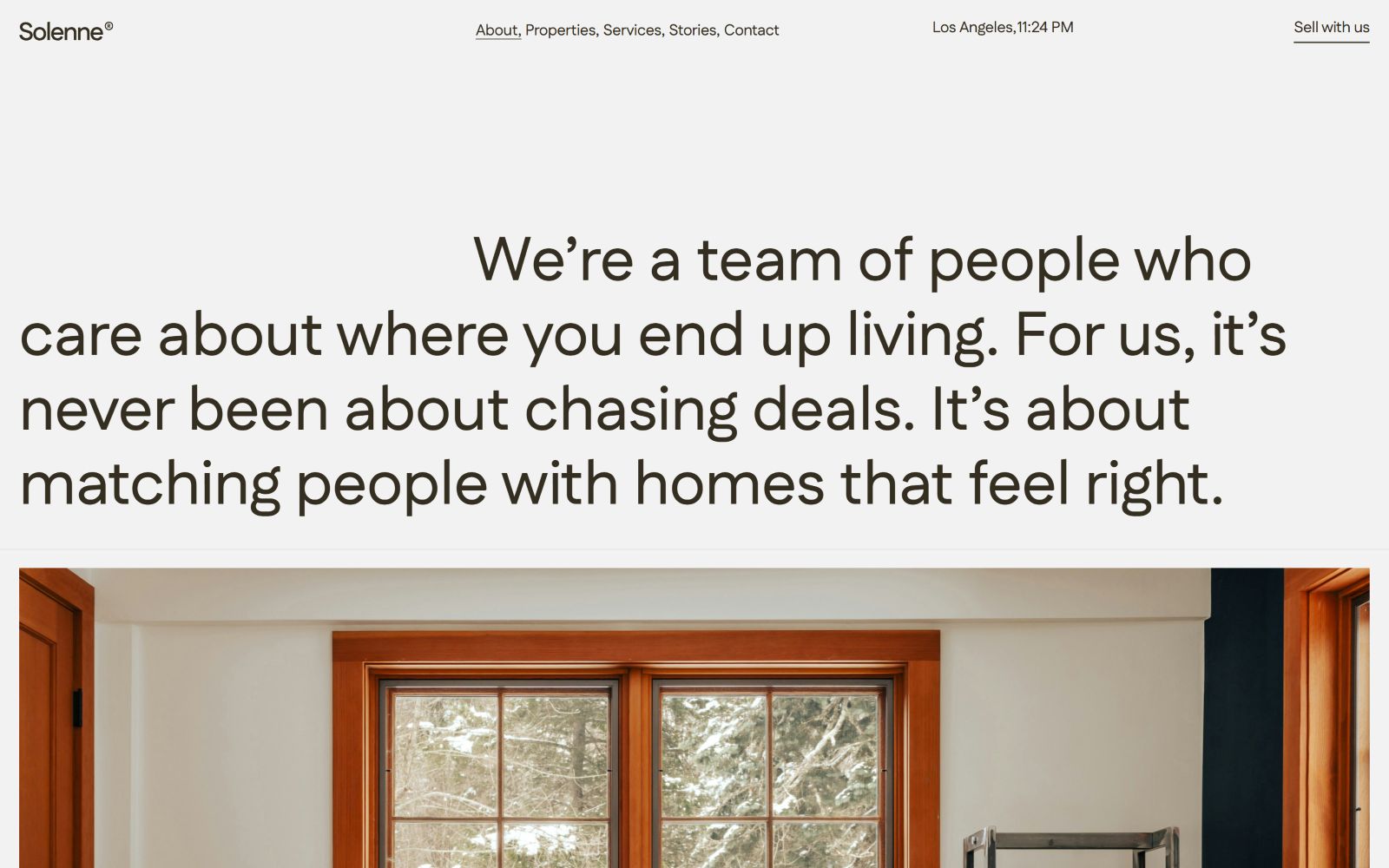 Slogan about matching people with homes, black text on white. Navigation links at the top; wooden window frame partially visible below.