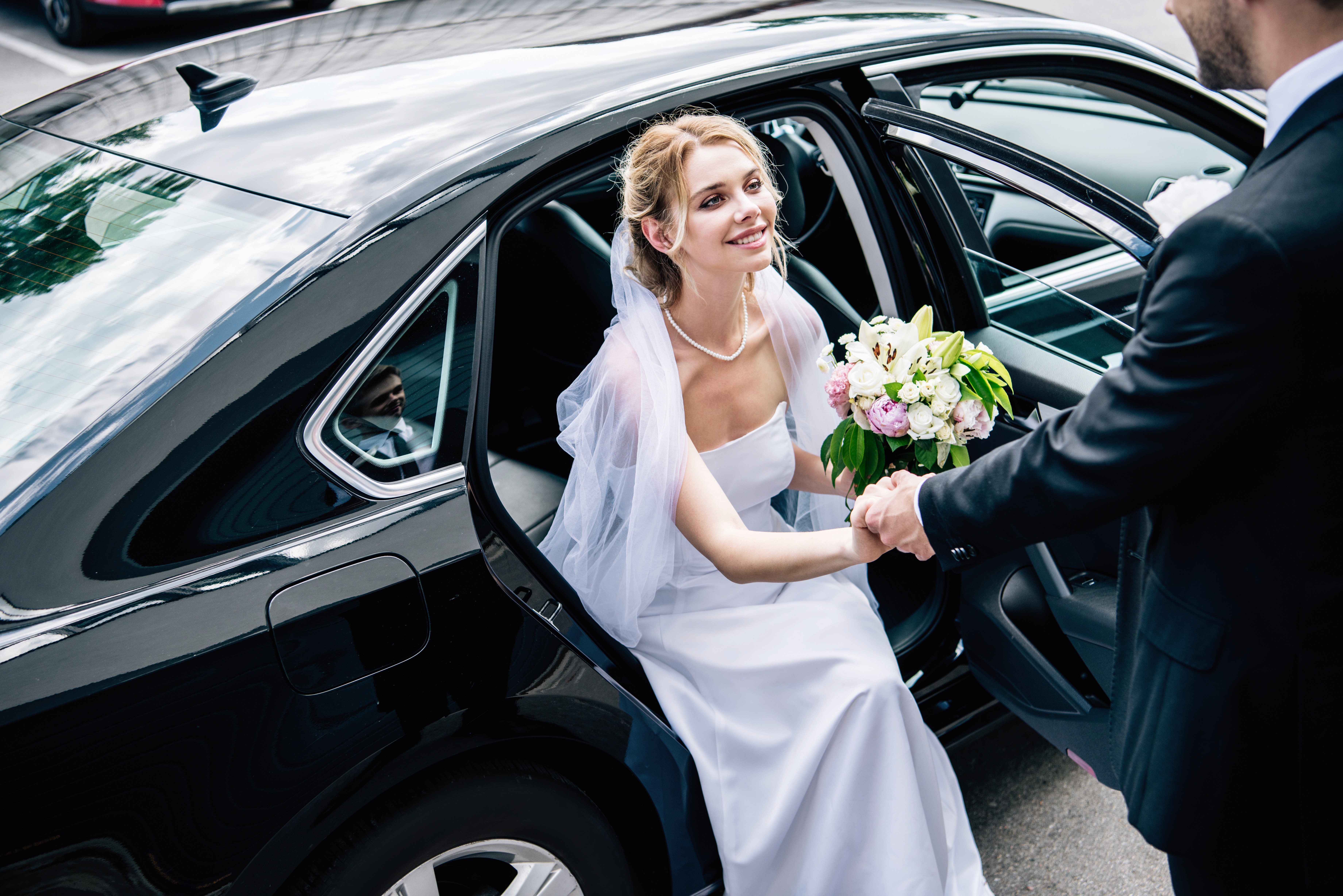 man in black suit holding woman in white dress