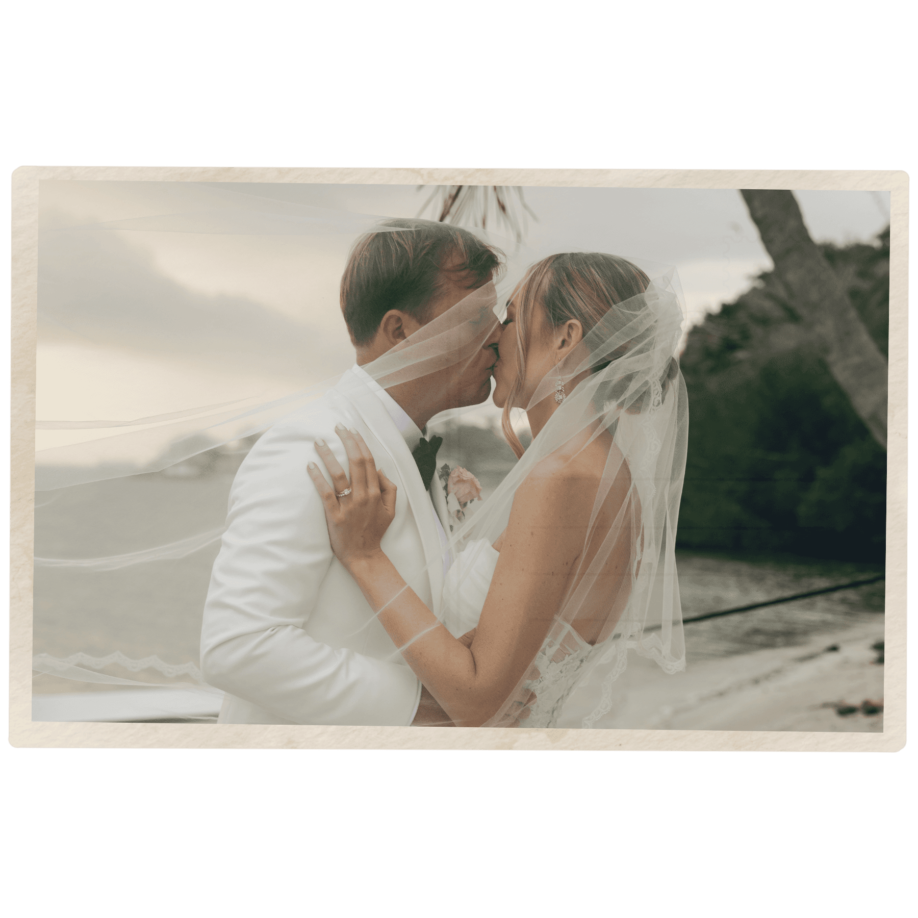 wedding photographer in south florida captures bride and groom kissing under the veil at golden hour.