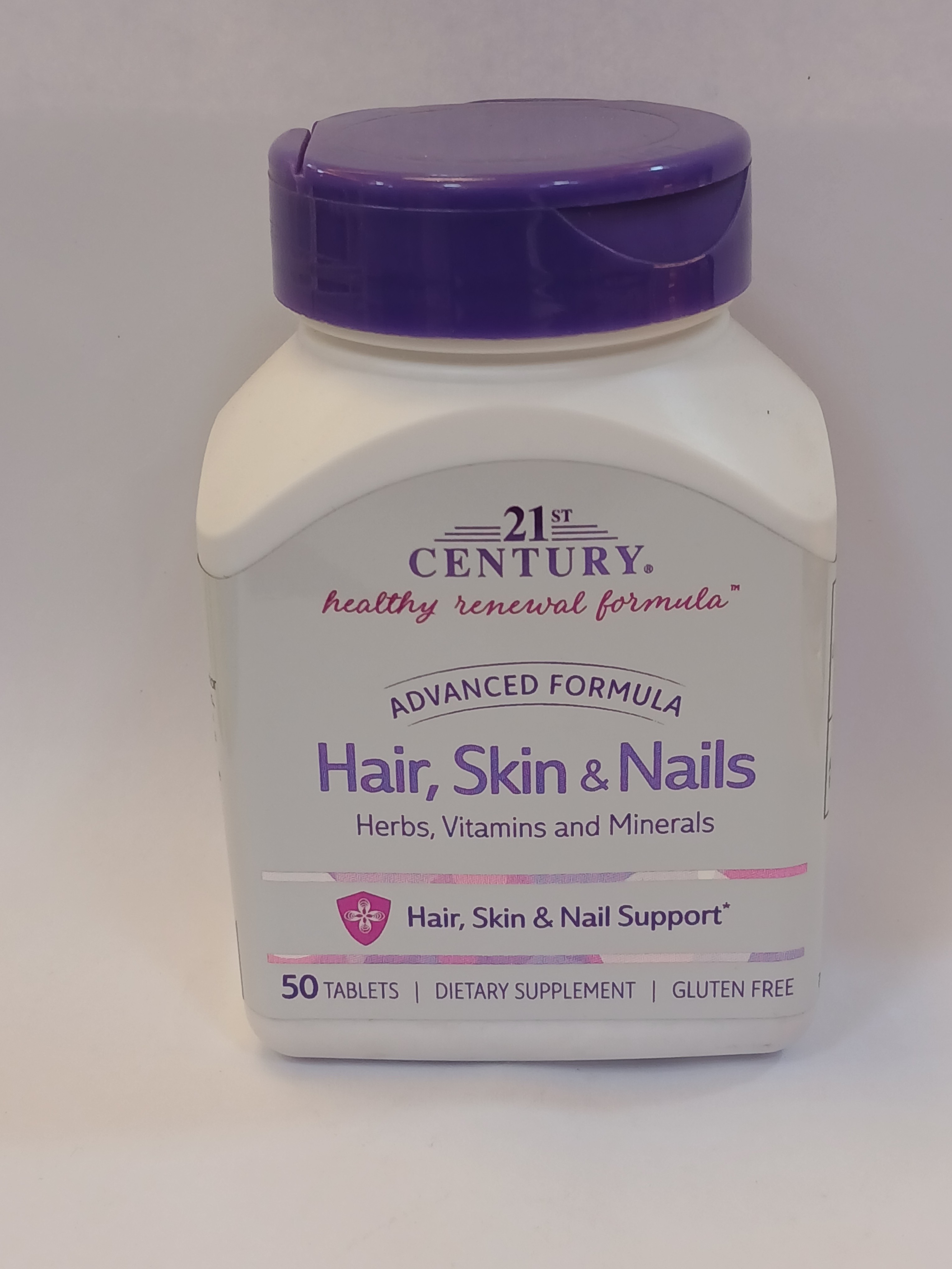 A white plastic bottle with a purple lid and label displays text about an advanced formula dietary supplement containing 50 tablets for hair, skin, and nail support.