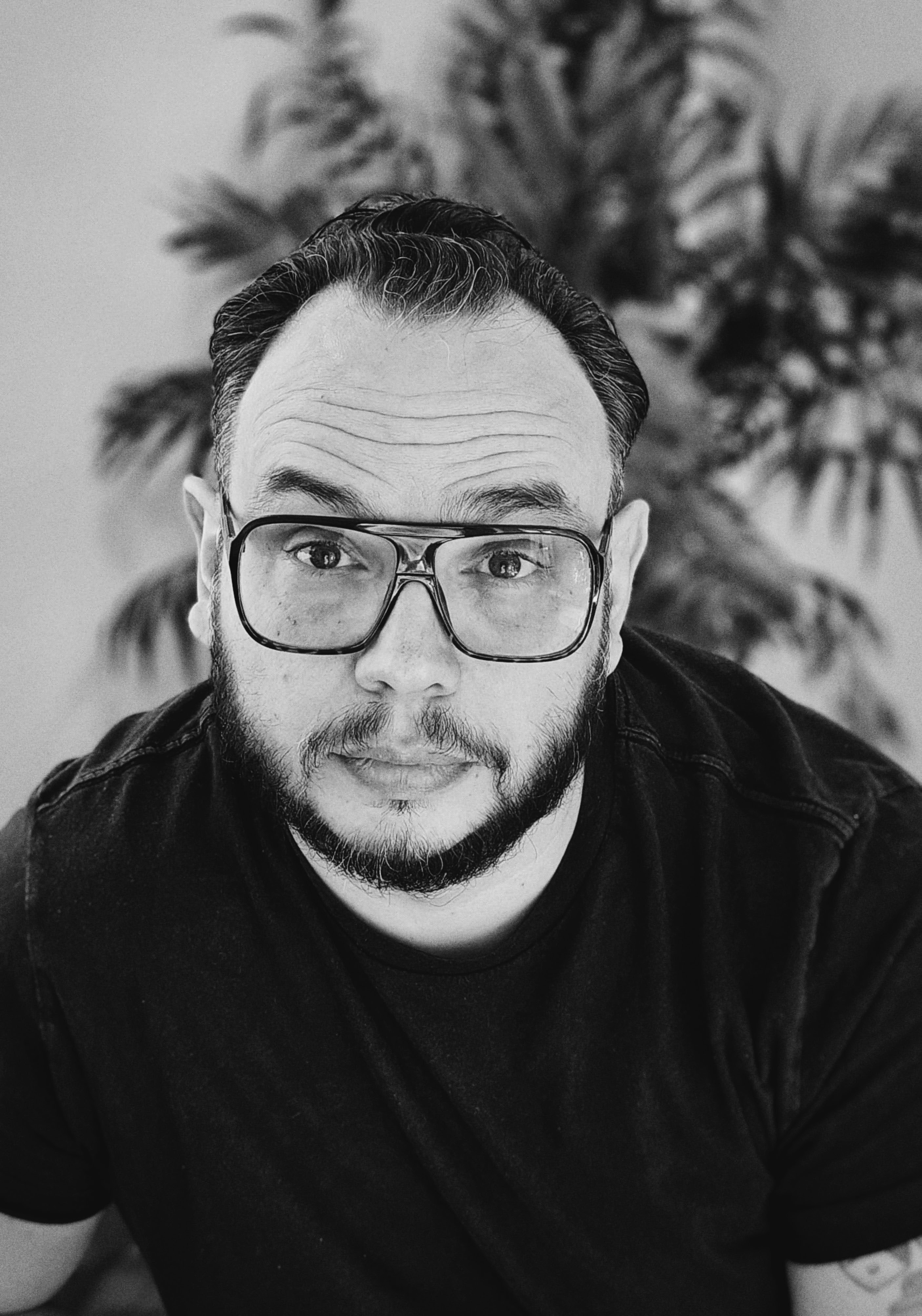 A photo of Stephen, looking at the camera with large glasses, and a desperate look of 'please hire me' on his face.