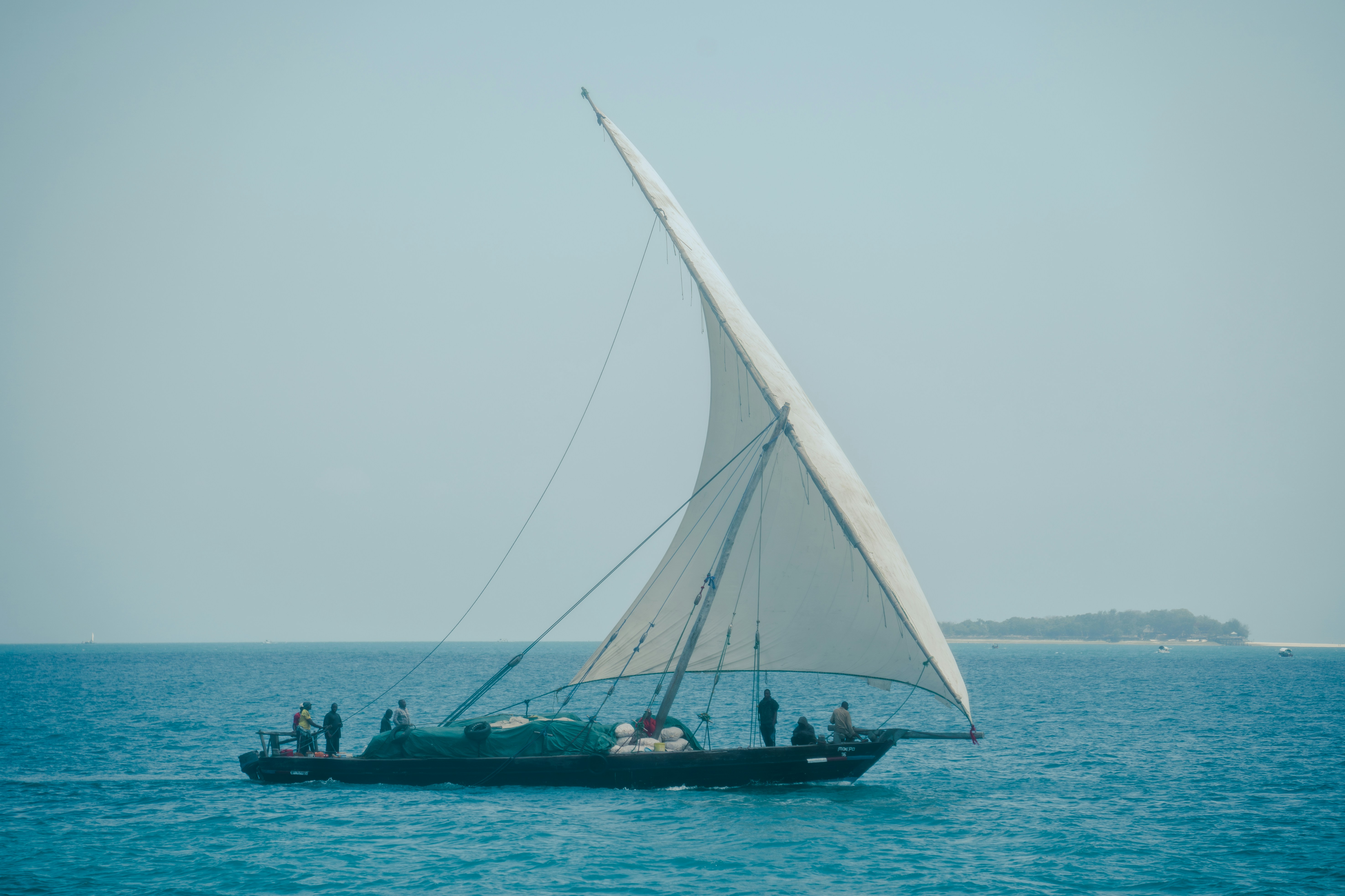 a sailboat with people on it in the ocean