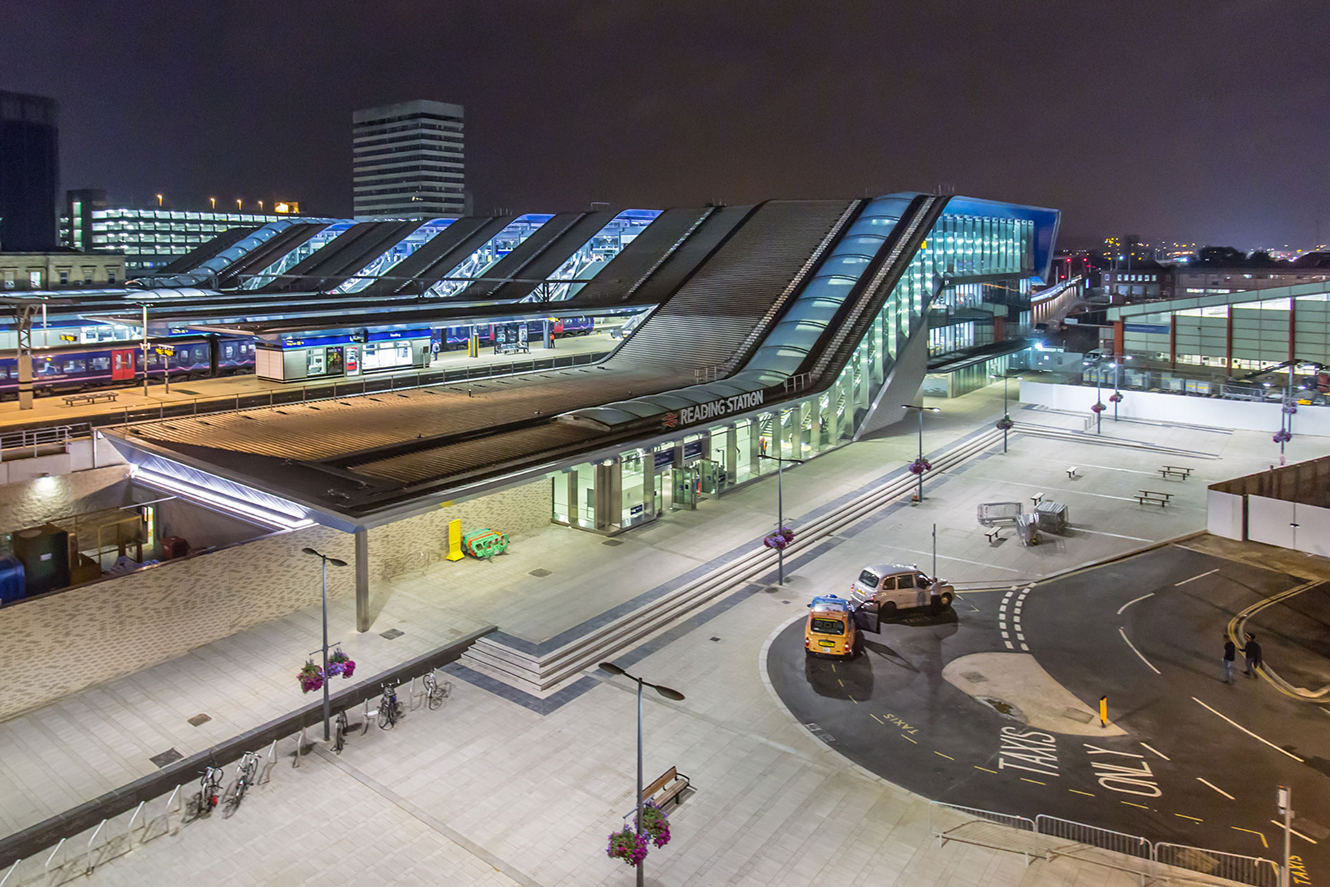 Modern building which is Reading train station at night with multiple lights