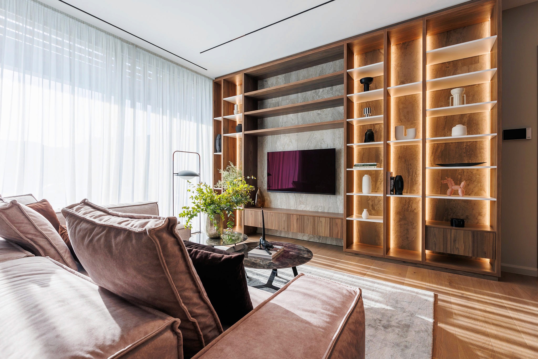 Villa Trio living room with custom TV wall, integrated shelving, and warm LED lighting by Roomzly