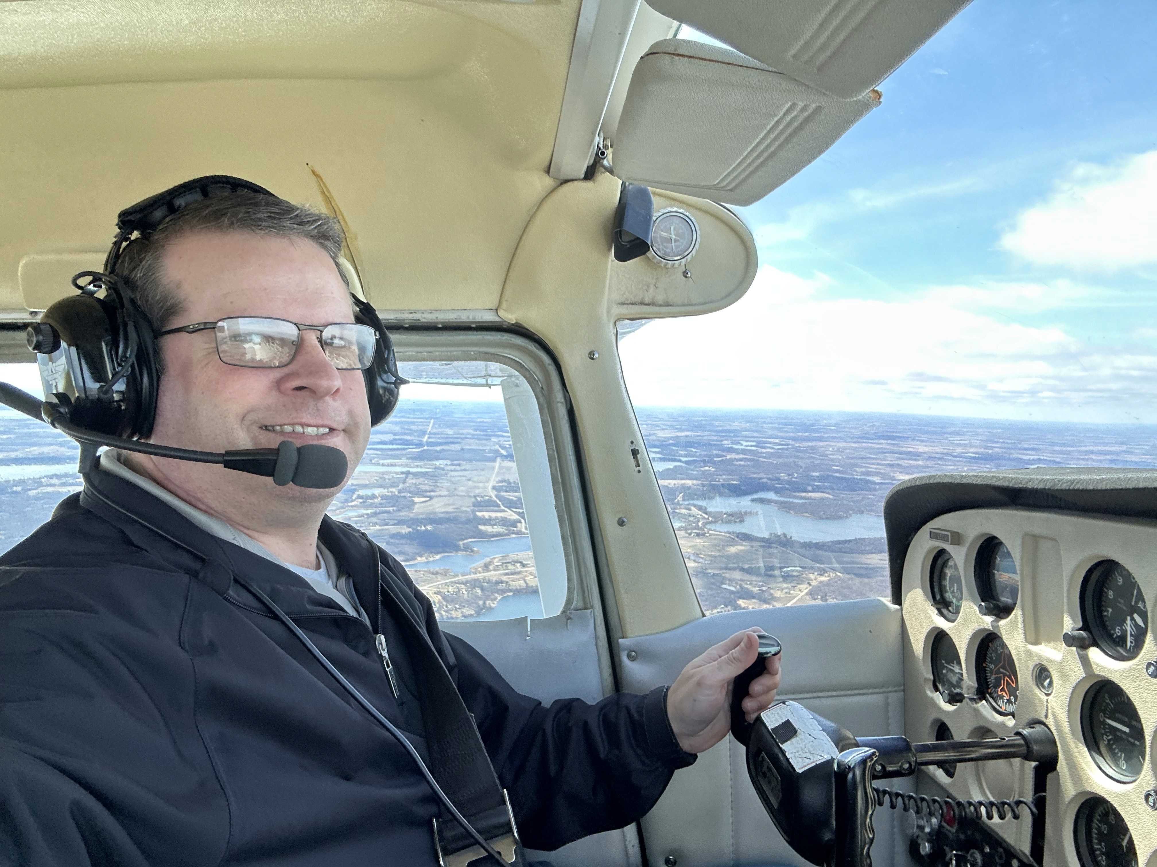 Tyler Wirth flying a small aircraft in clear daylight.