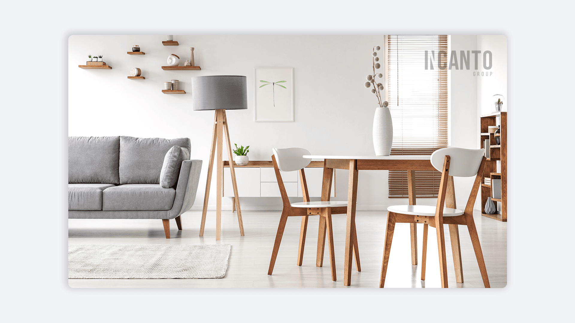 Living minimalista con sofá gris, mesa de madera y luz natural, reflejando el estilo de diseño de Incanto Group.