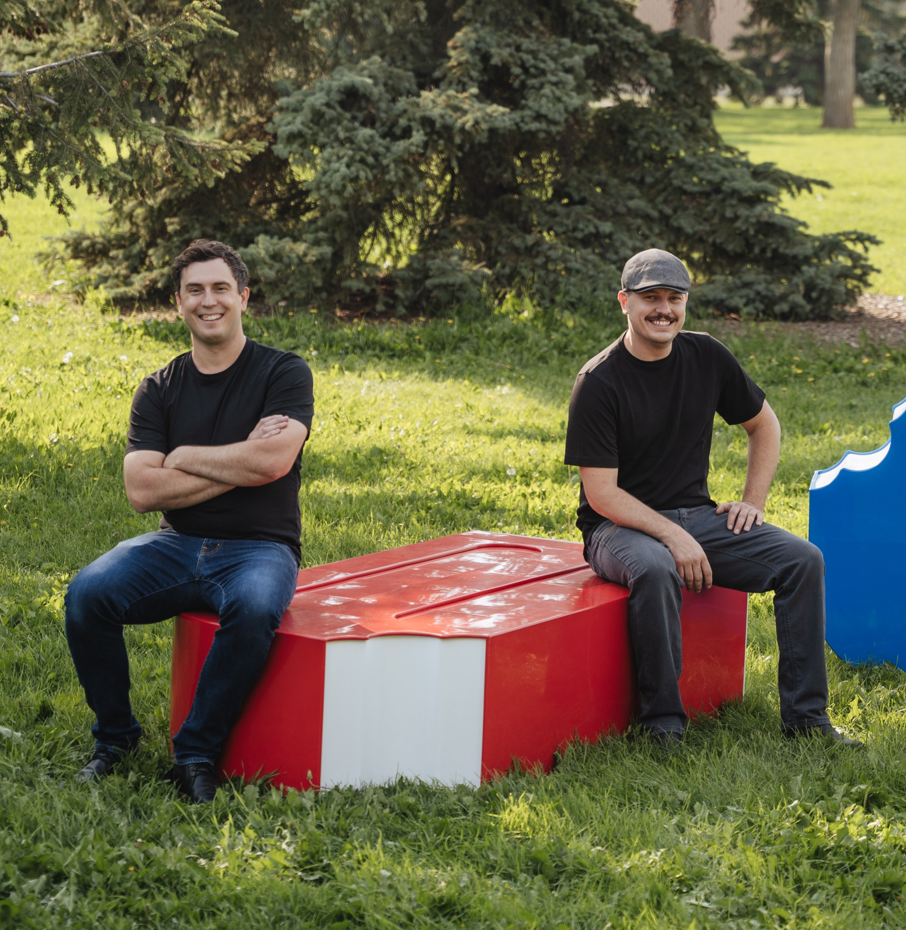 Two men sit on a couple of benches made to look like popsicles
