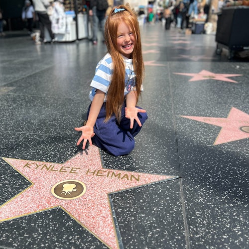 A Hollywood Walk of Fame area Tourist is happy with their own replica star personalized for a photo.#kids