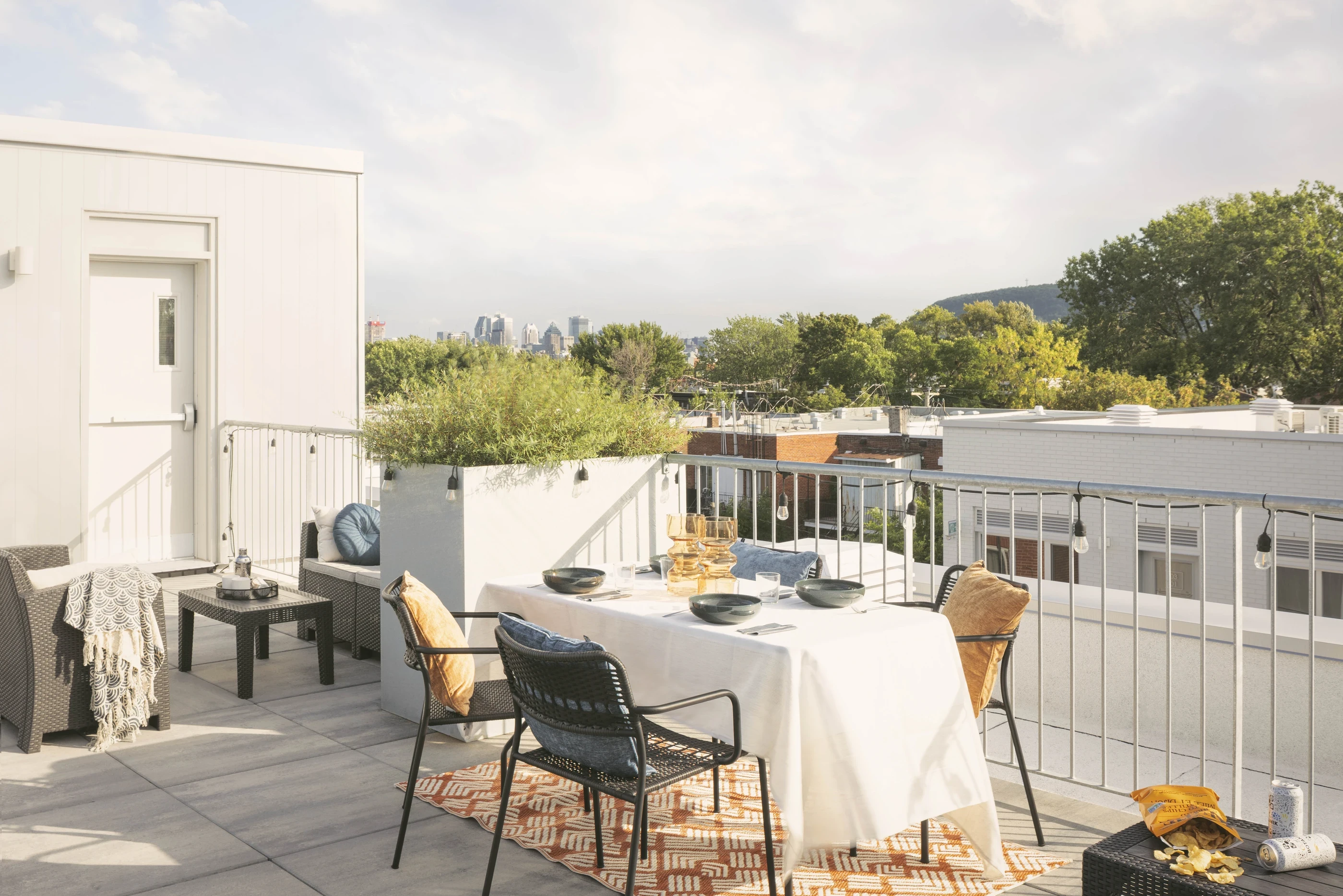 Aménagement d’une terrasse sur le toit d’un immeuble résidentiel à Montréal avec table à manger extérieure et garde-corps métallique