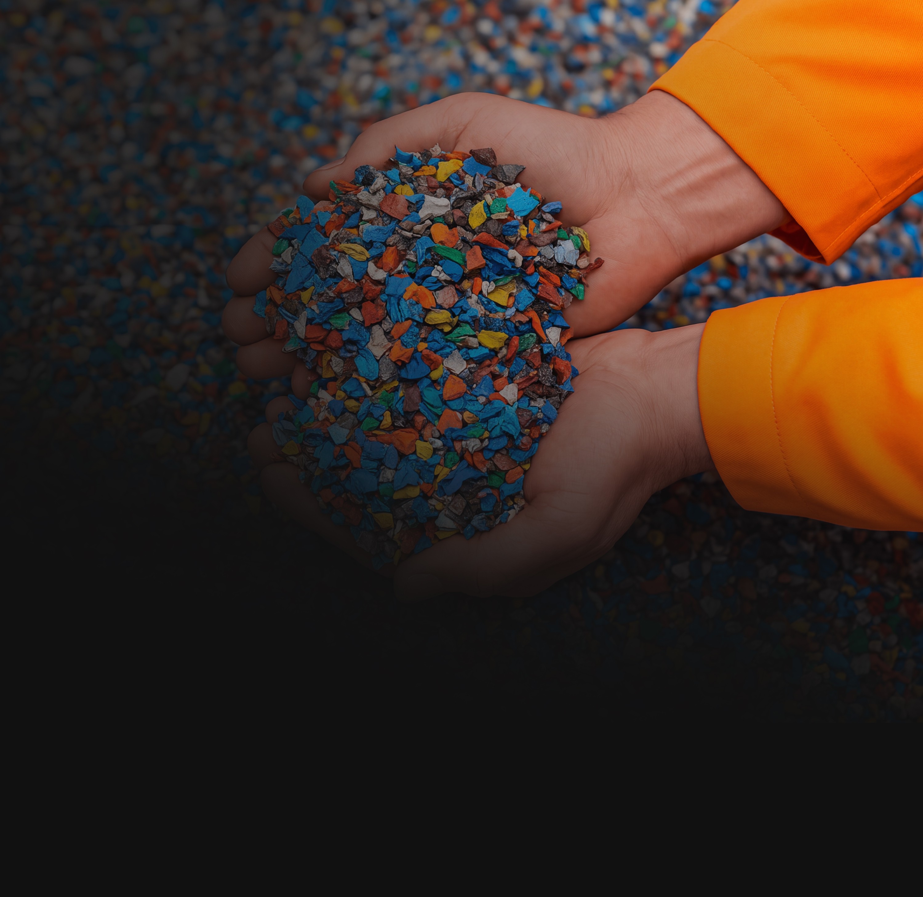 Hands holding recycled multicolor plastic regrind