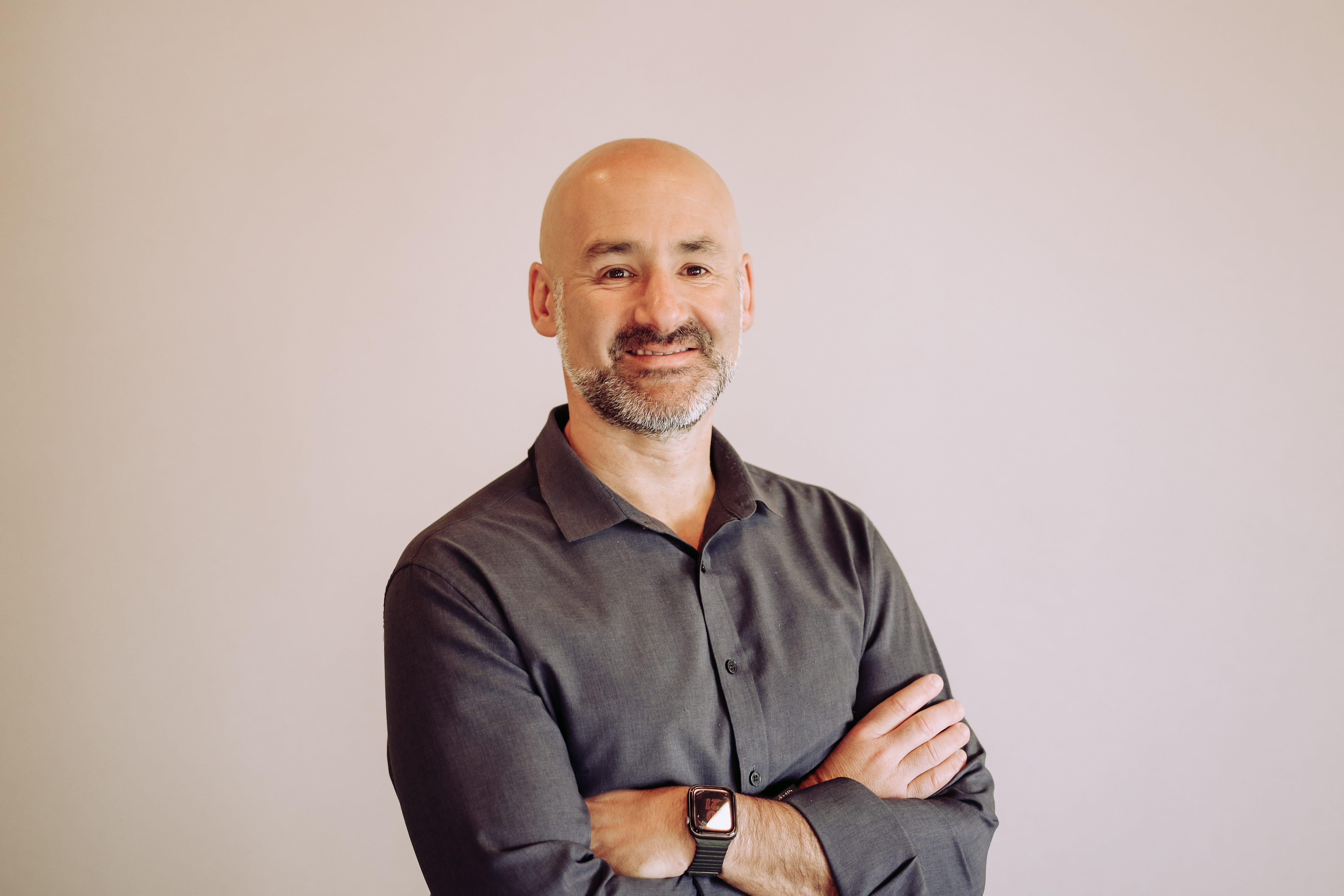 A headshot of a smiling male doctor.