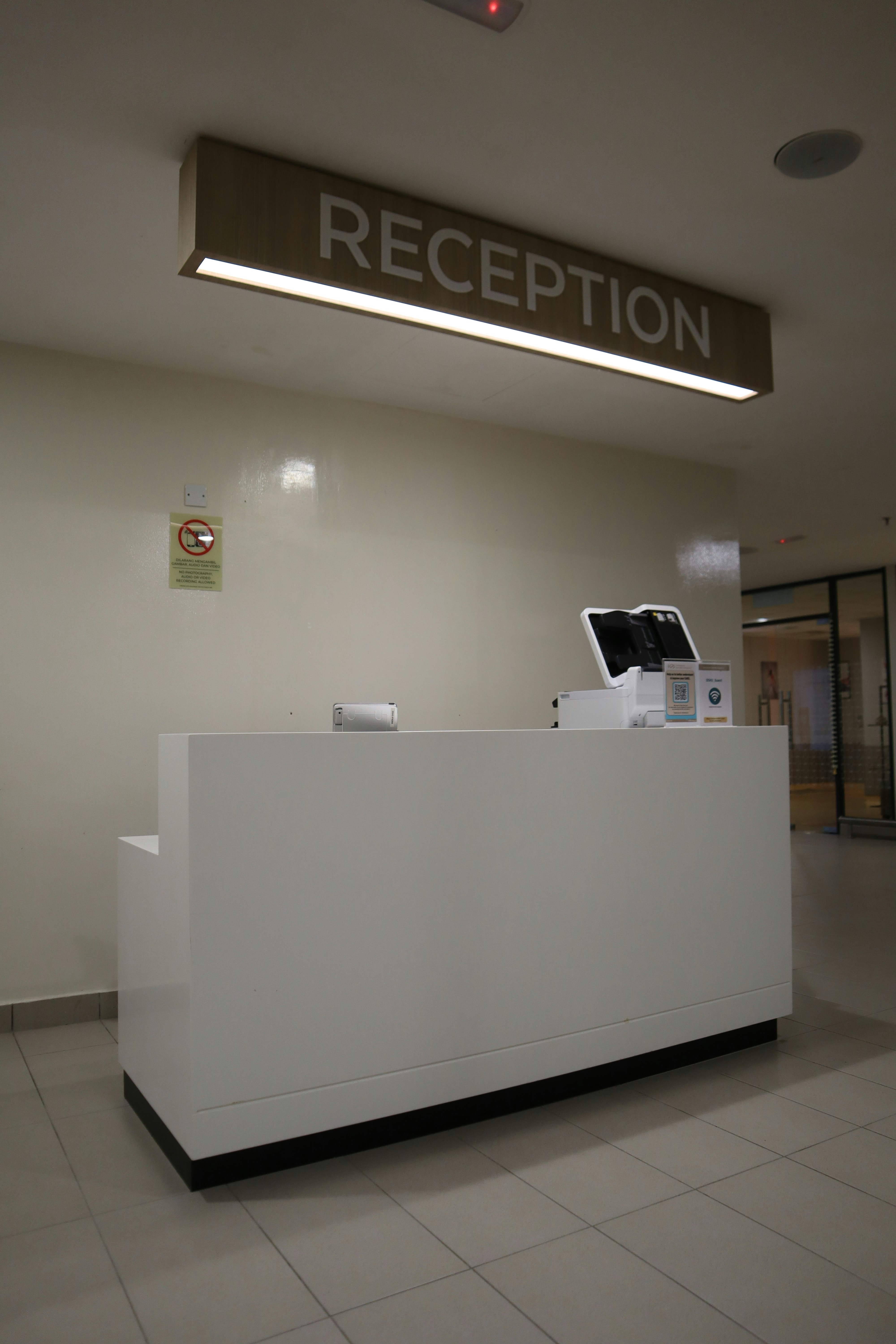 Modern reception desk with sign overhead.