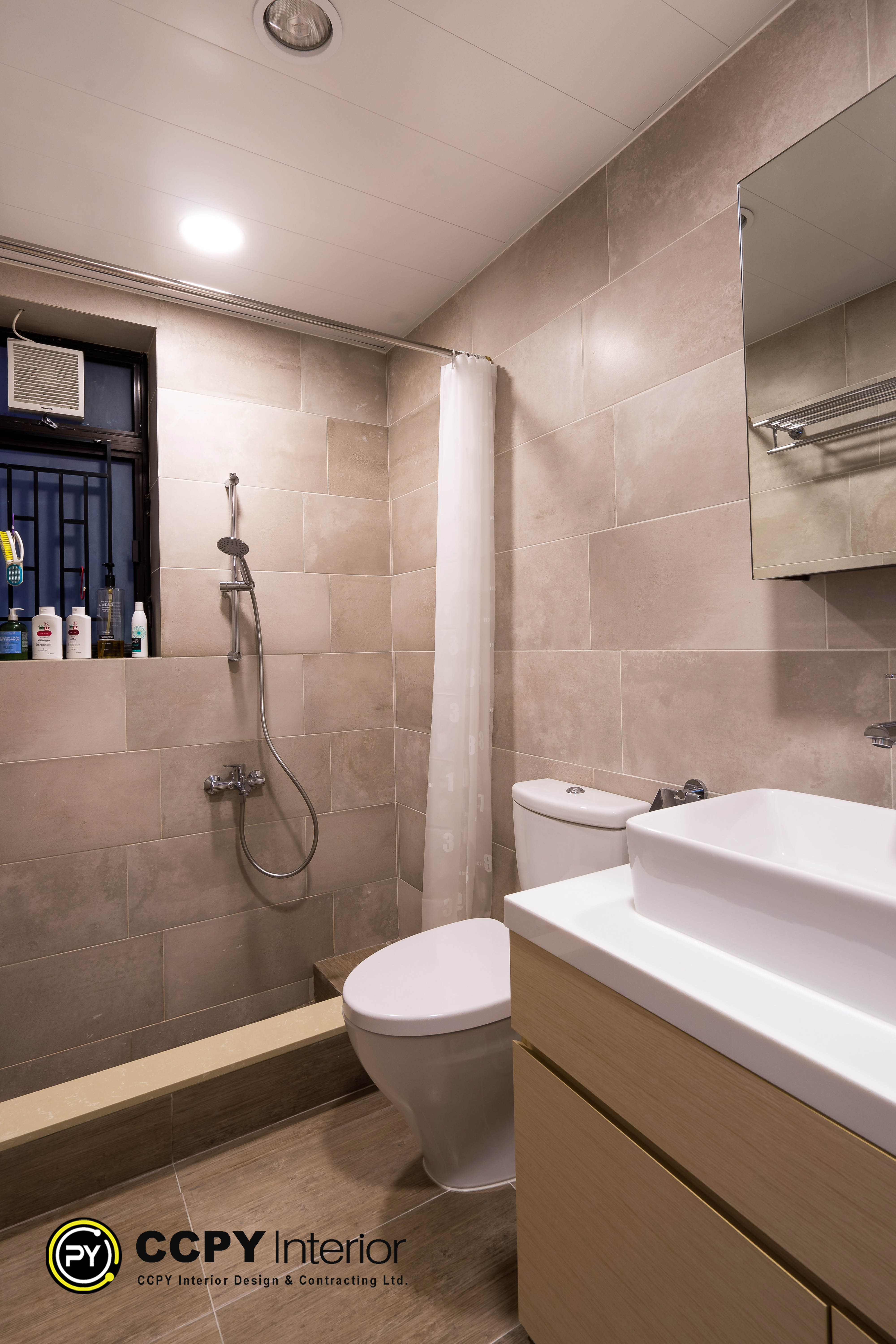 Earthy bathroom design tiles in Castello create a warm atmosphere, complemented by a light wood vanity and a minimalist white vessel sink.
