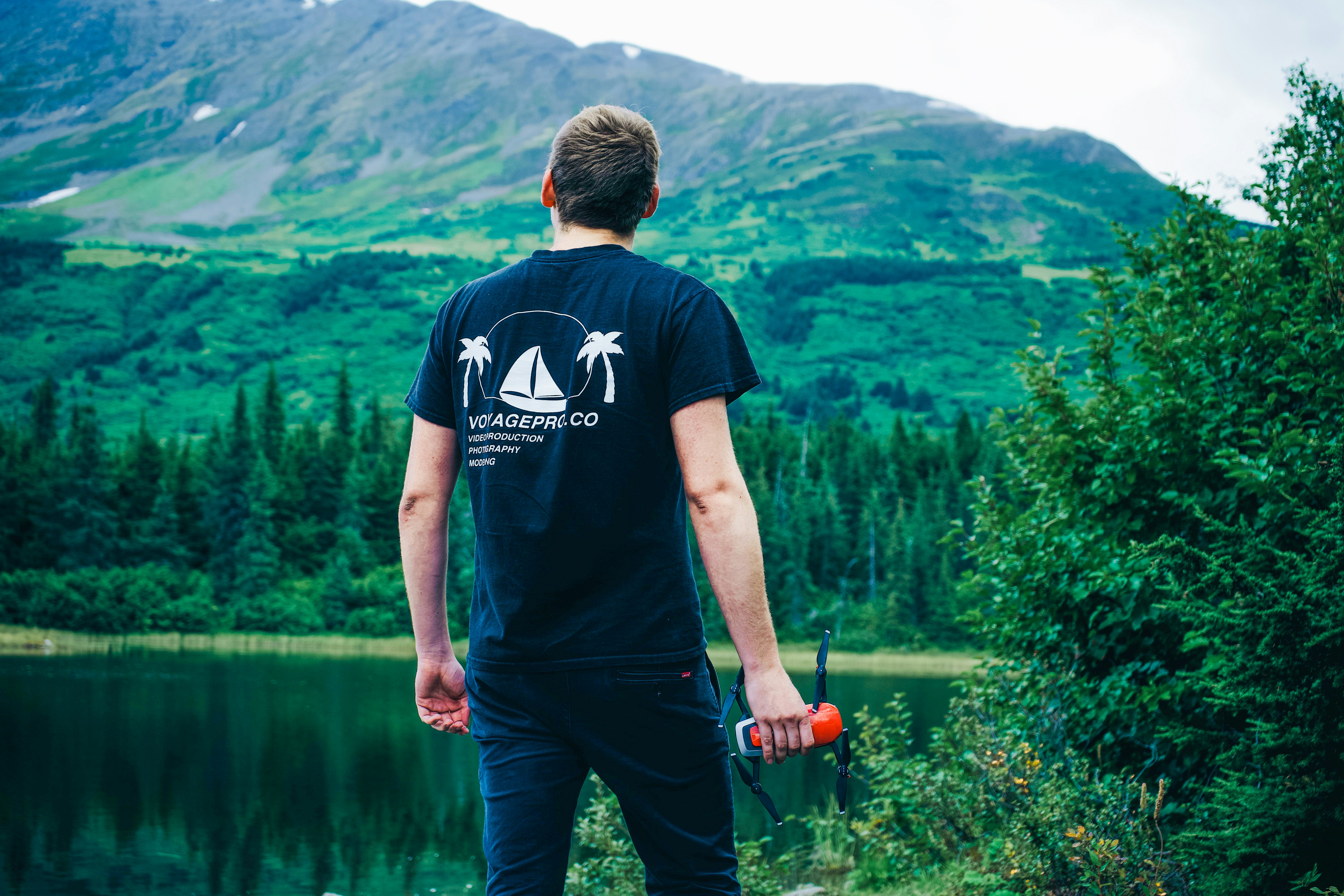 a man standing on a rock near a body of water