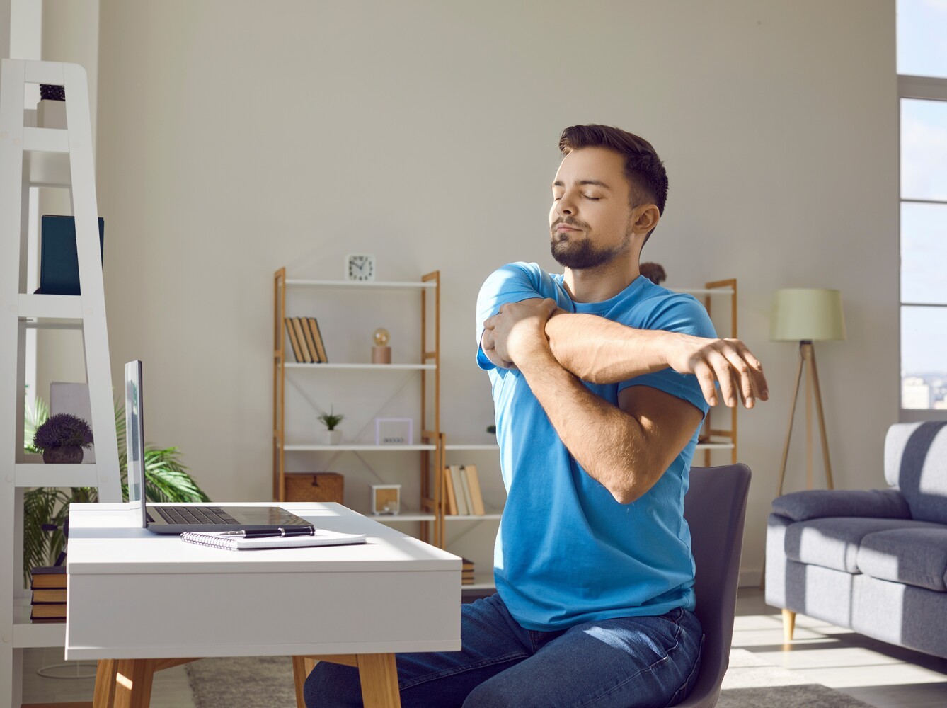 man doing a gentle seated workout for fat loss at his desk while taking a break from work