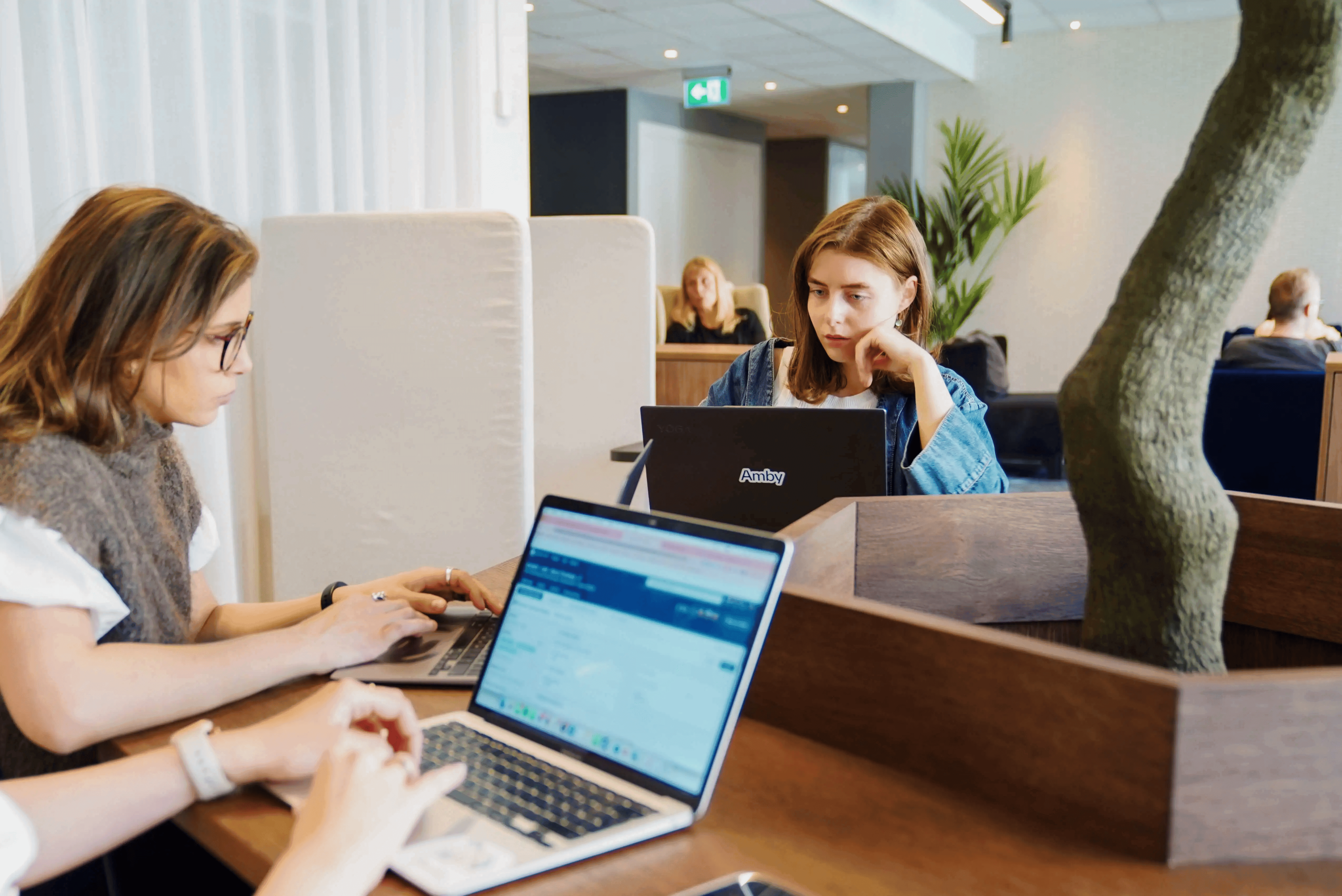 Two women collaborating and working at office desk for recruiters showing teamwork